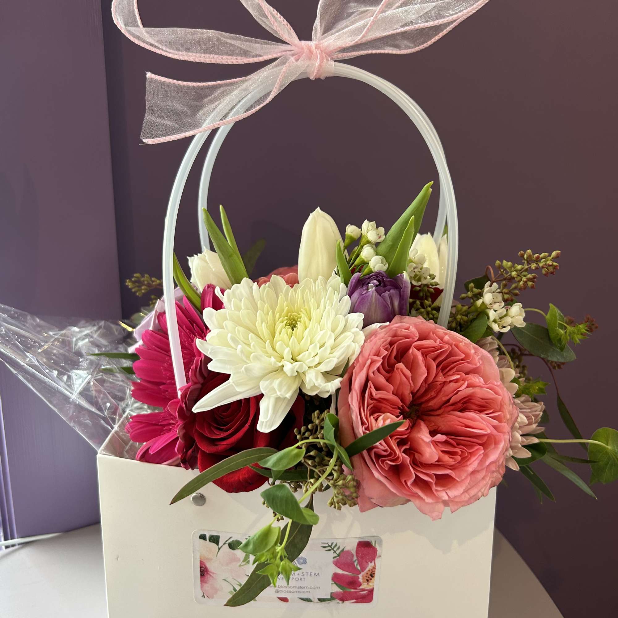 Mixed flower arrangement in a white gift box with a pink ribbon bow