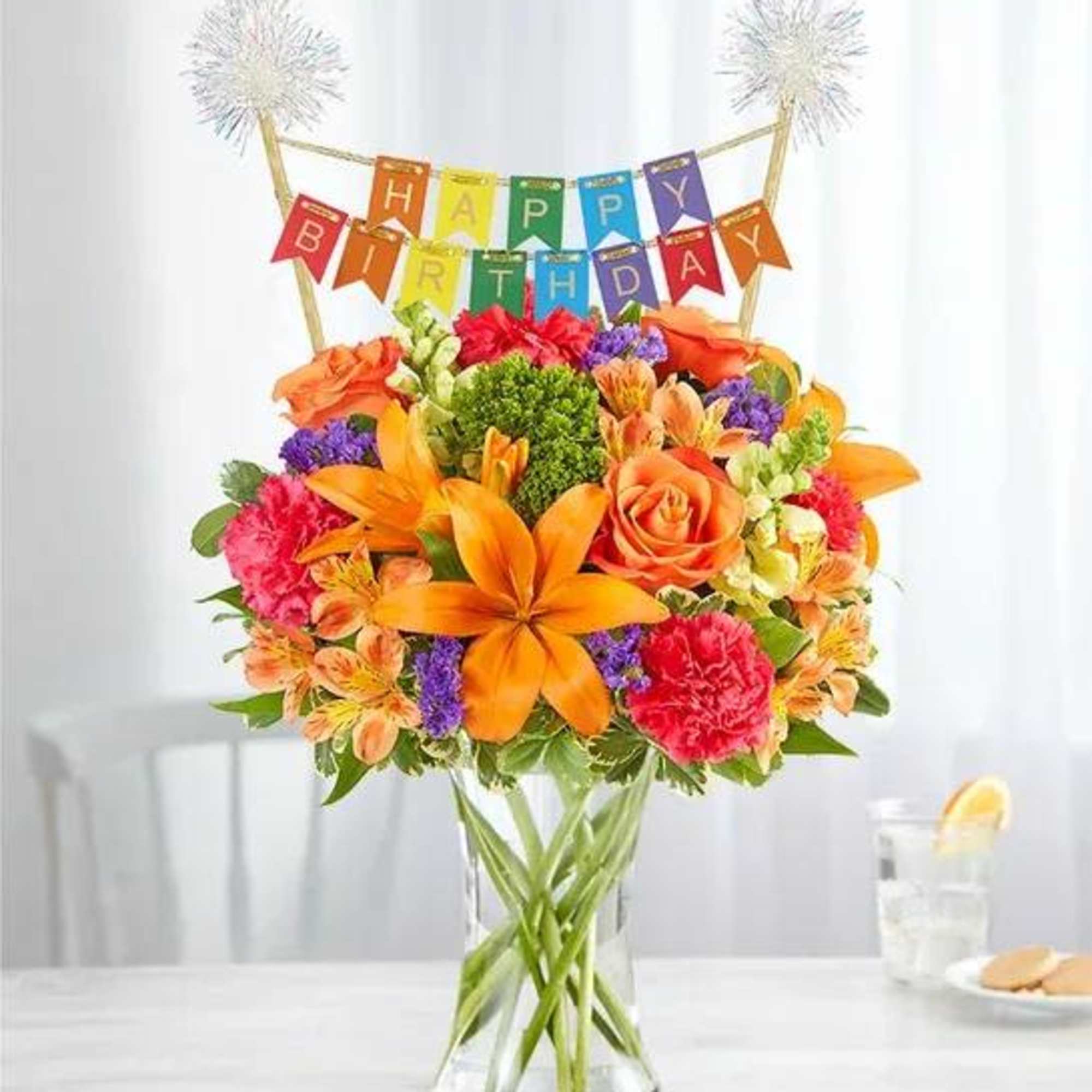 Birthday bouquet in a glass vase with a colorful banner topper