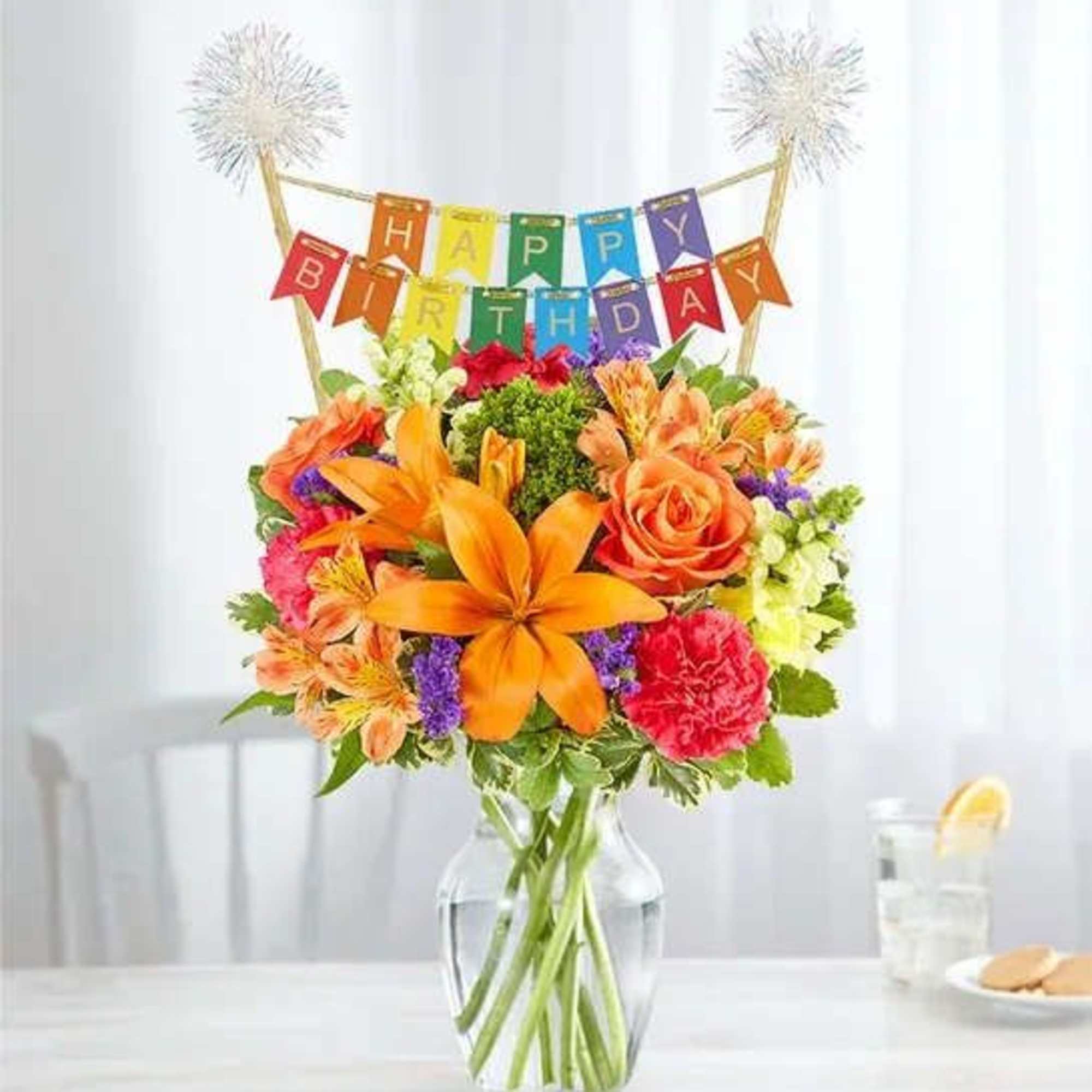 Birthday bouquet in a glass vase with a colorful banner topper
