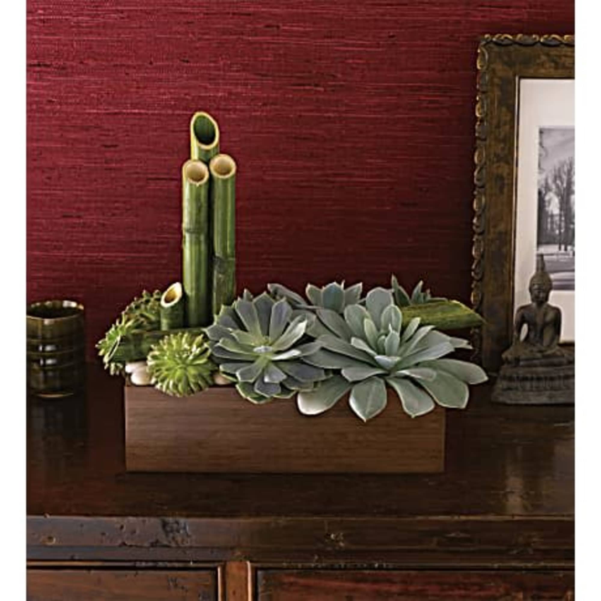 Succulent arrangement with bamboo stalks in a wooden planter