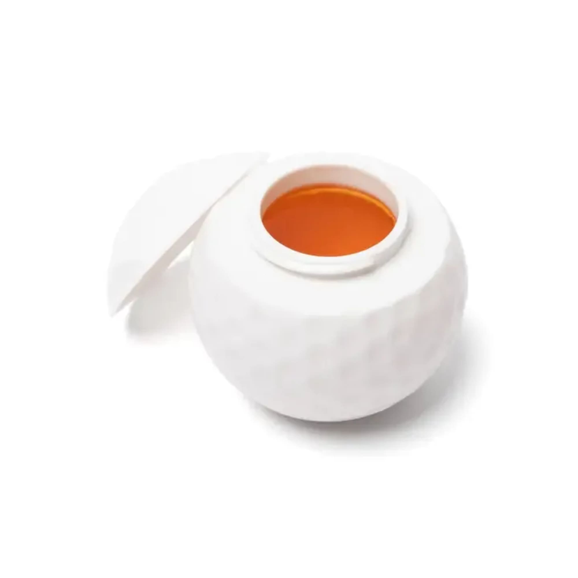 White round candle jar with orange wax inside