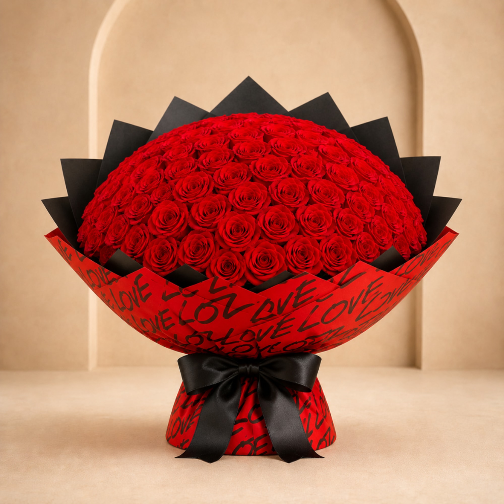 Large bouquet of red roses wrapped in red paper with black ribbon