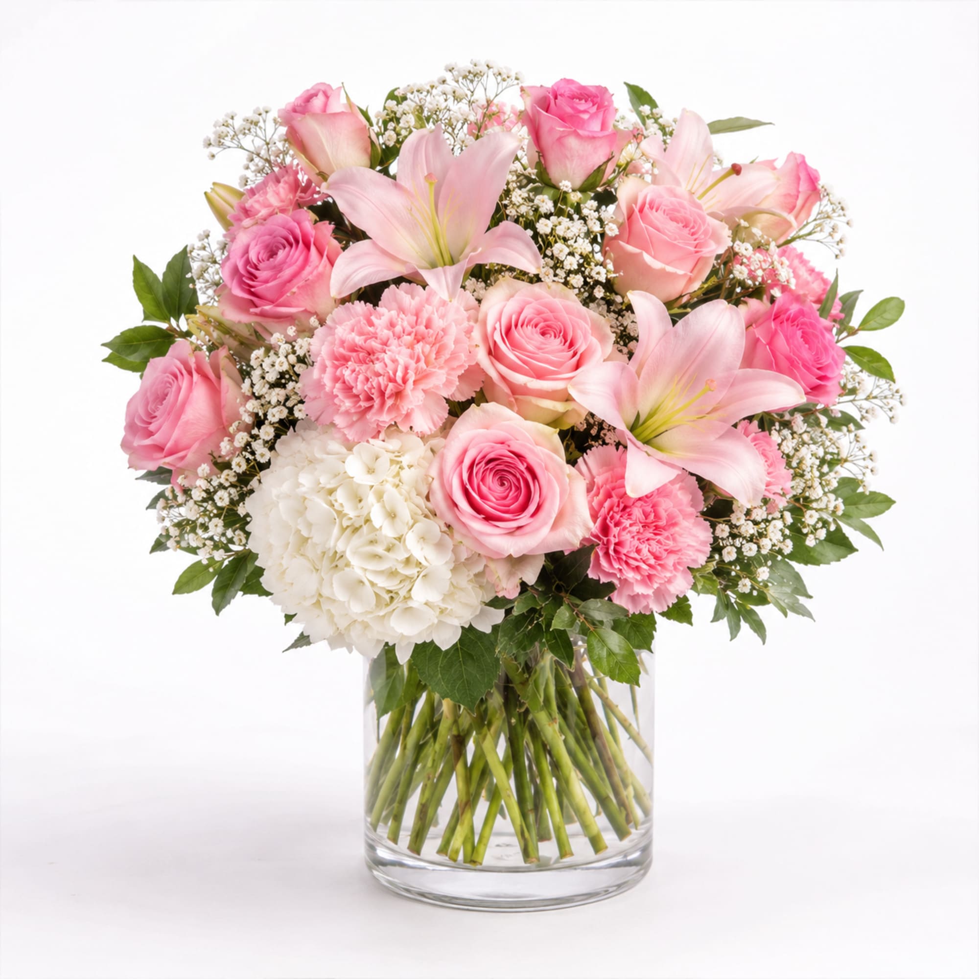Soft blush roses and pale pink lilies form a rounded, romantic bouquet
