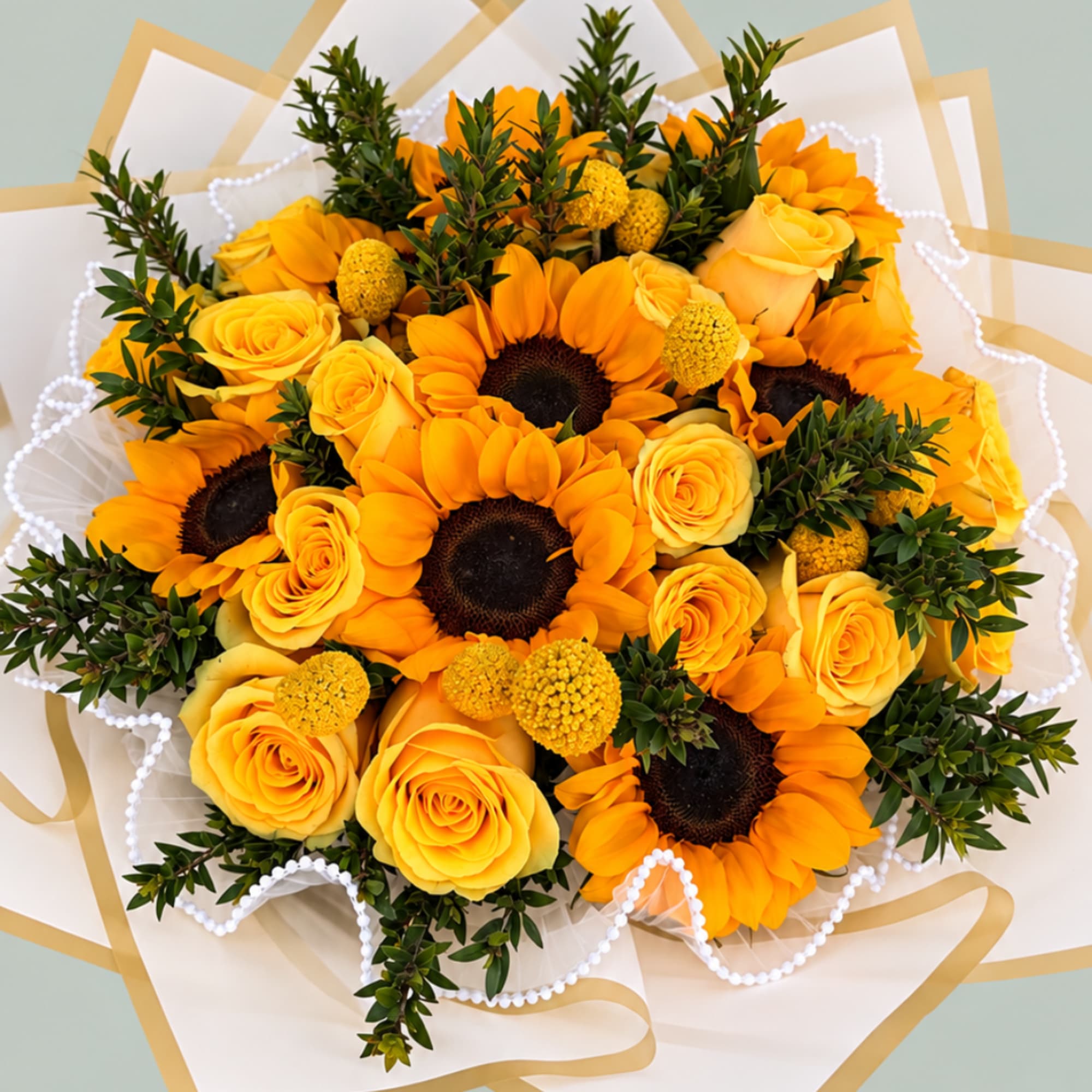 Yellow and orange bouquet with sunflowers and roses wrapped in white paper