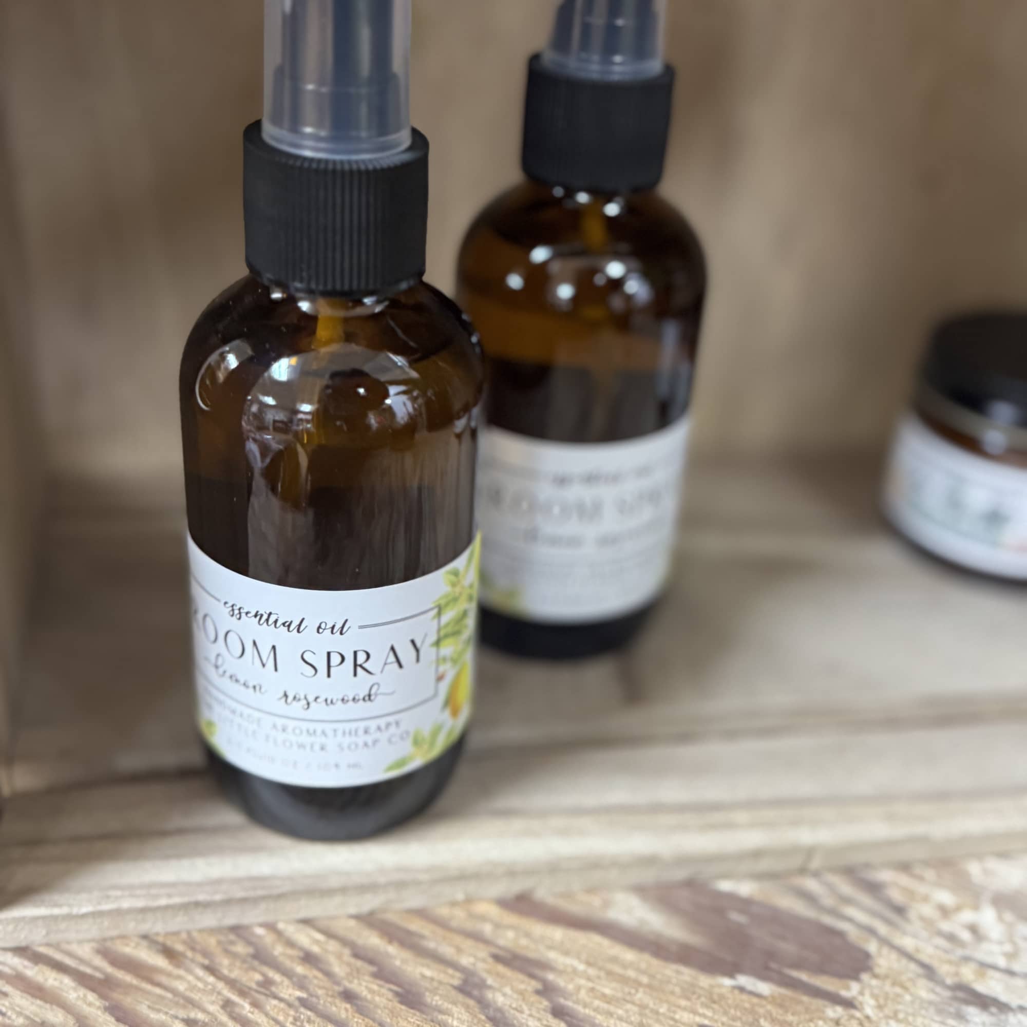 Two amber spray bottles on a wooden surface