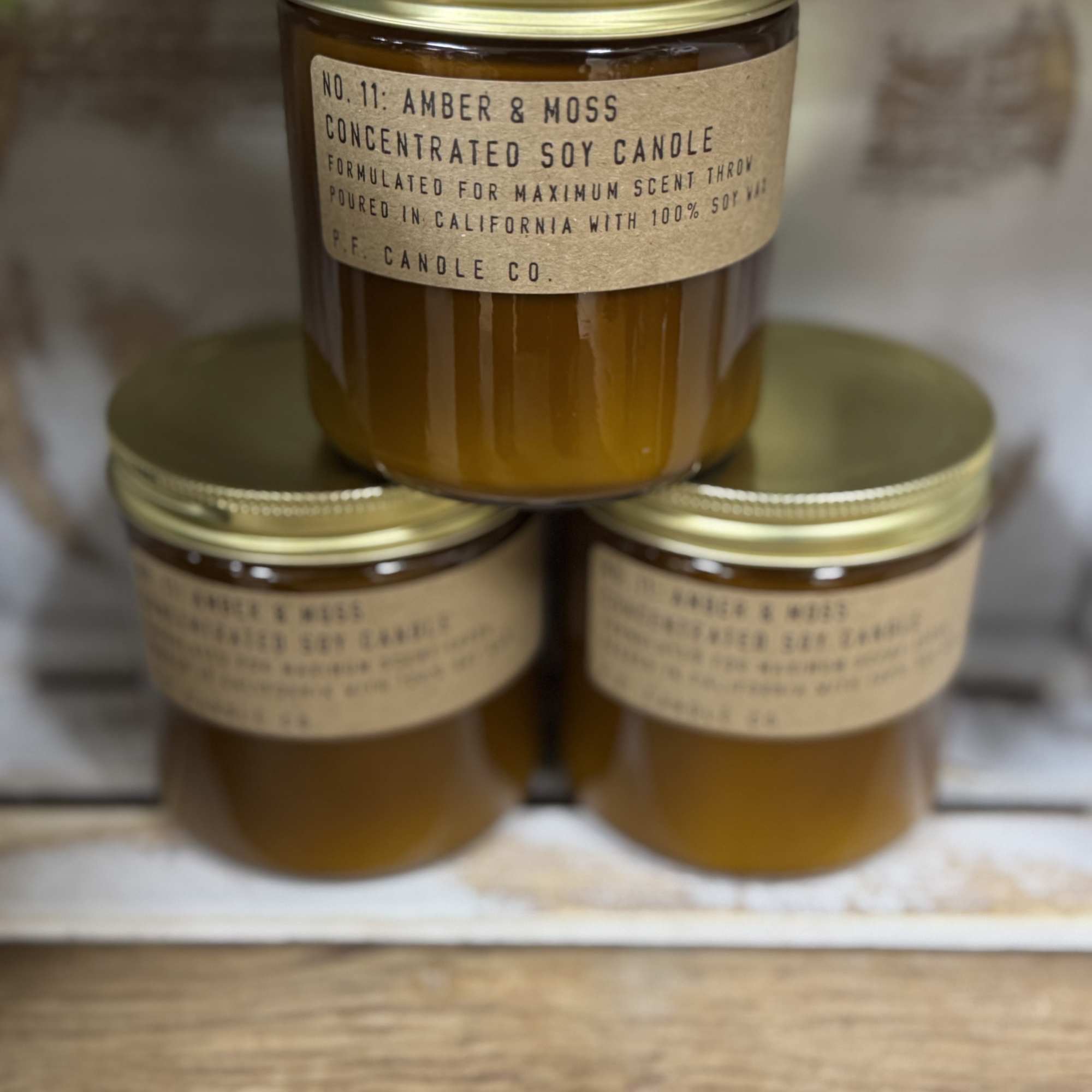 Three amber soy candles in glass jars with gold lids