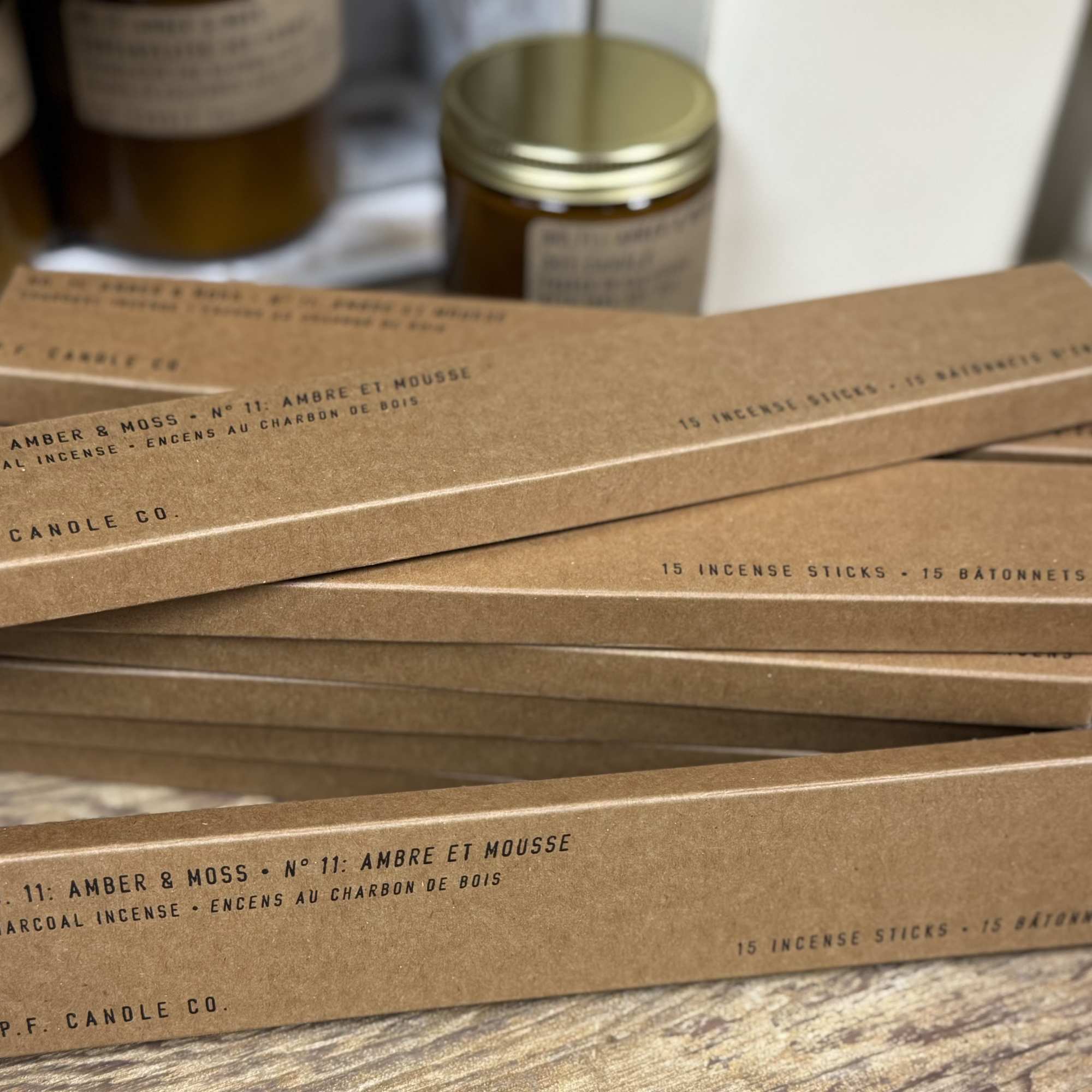 Stacked incense stick boxes with amber and moss labeling