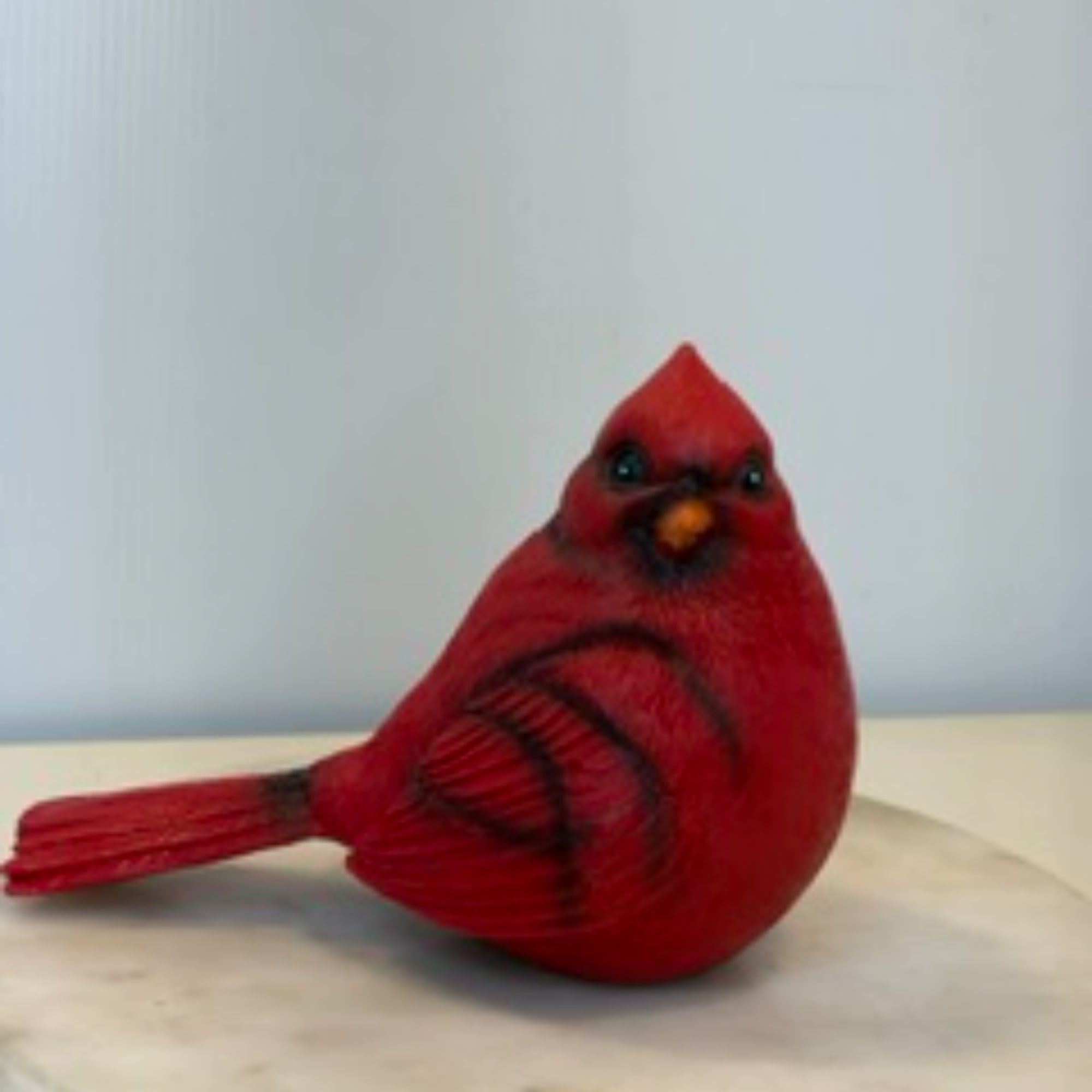 Red cardinal figurine on a light surface