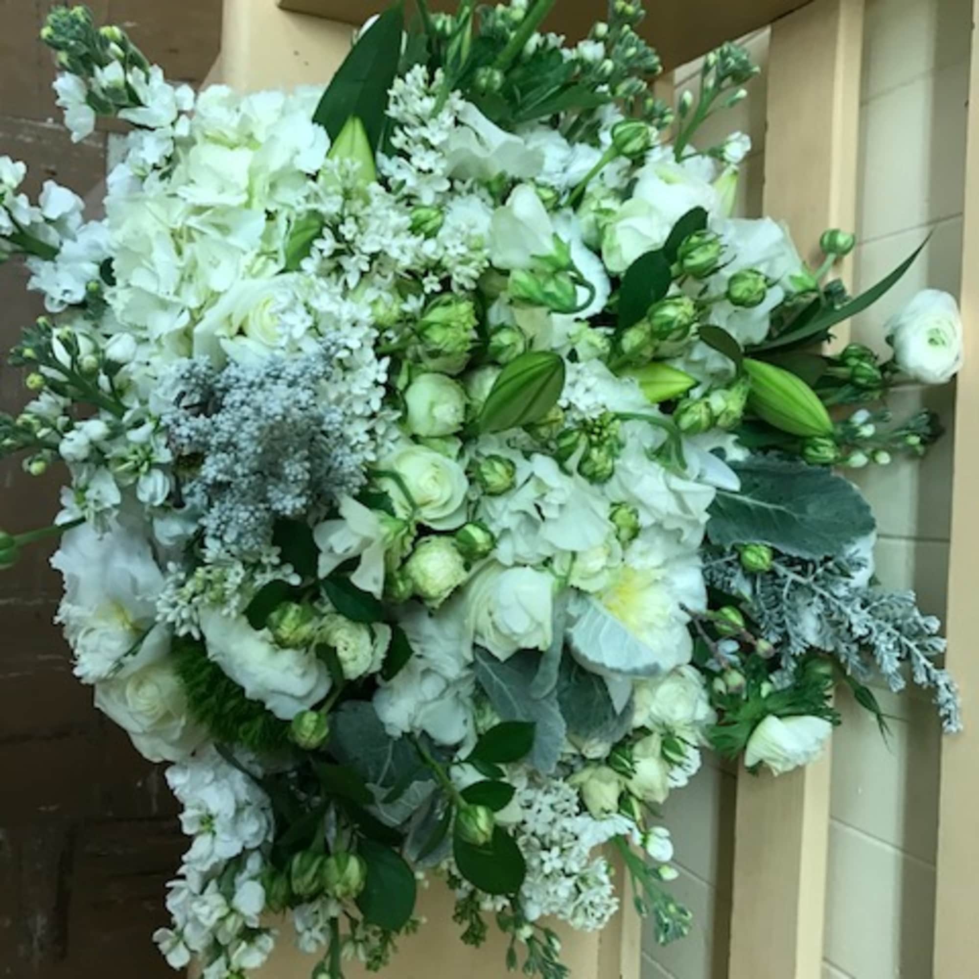 Large white floral spray with mixed blooms and greenery