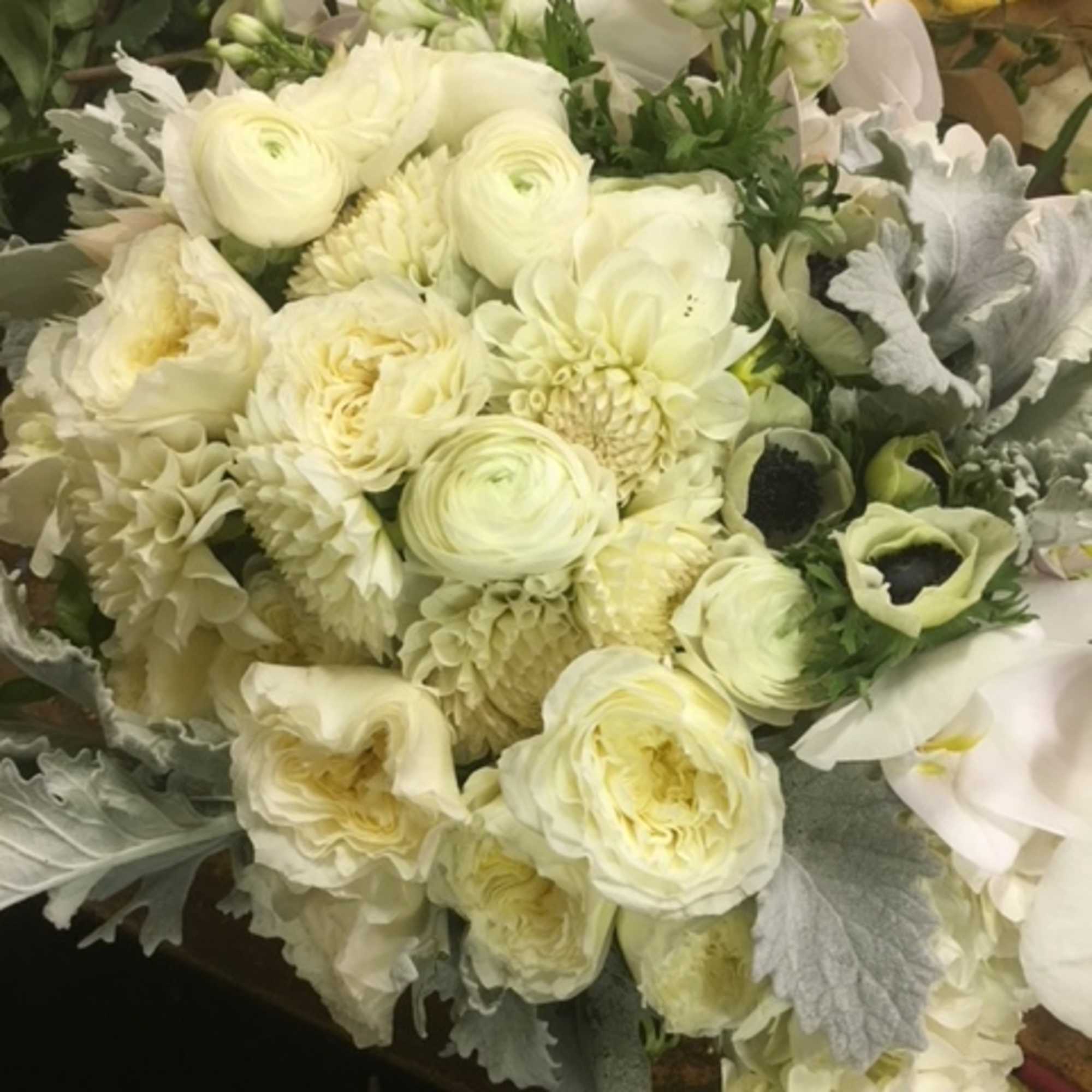 Creamy white bouquet with ranunculus, dahlias, and orchids