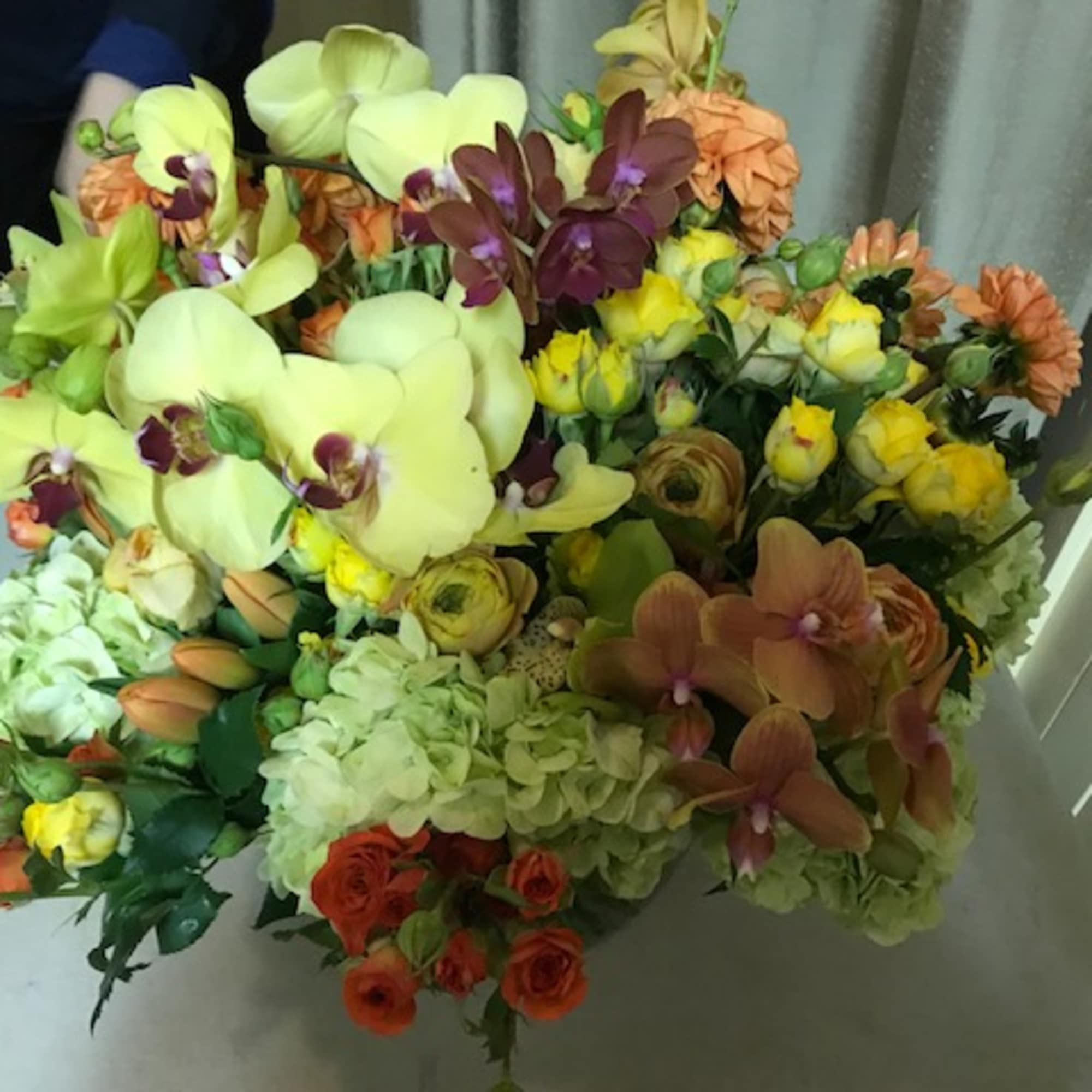 Mixed bouquet with orchids, roses, hydrangeas, and yellow blooms
