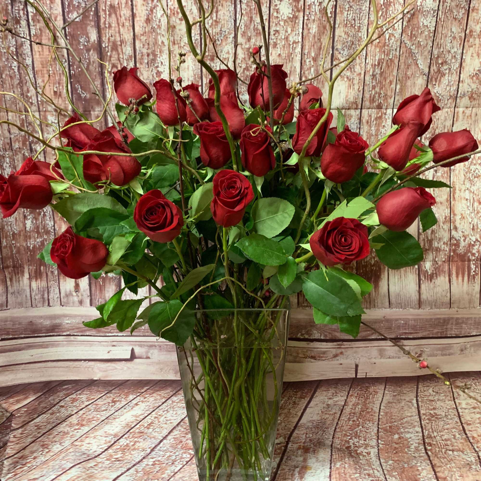 Red roses arranged in a clear glass vase