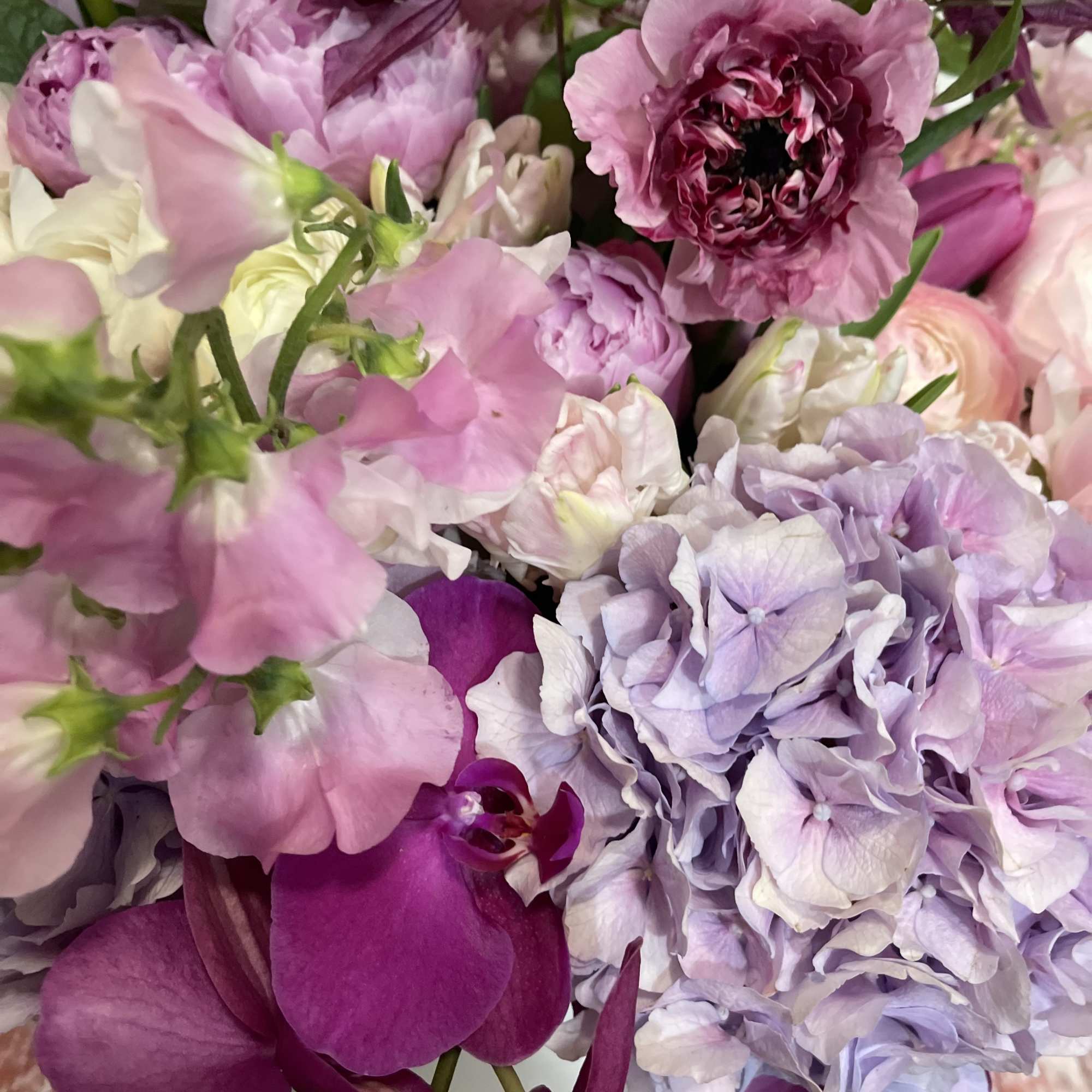 Pink and lavender flowers with deep purple orchids in a bouquet