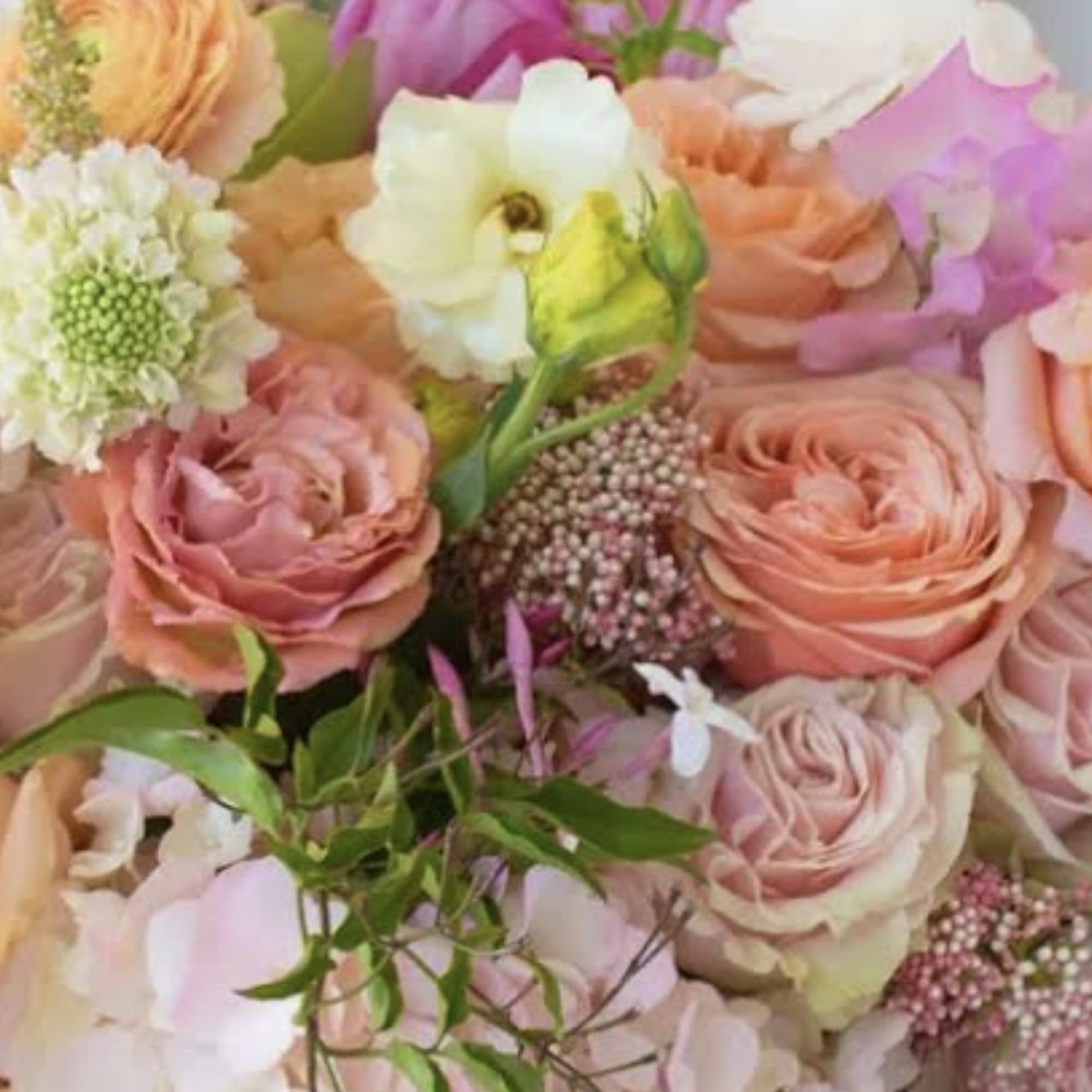 Pastel bouquet of roses and mixed blooms in pink, peach, and white