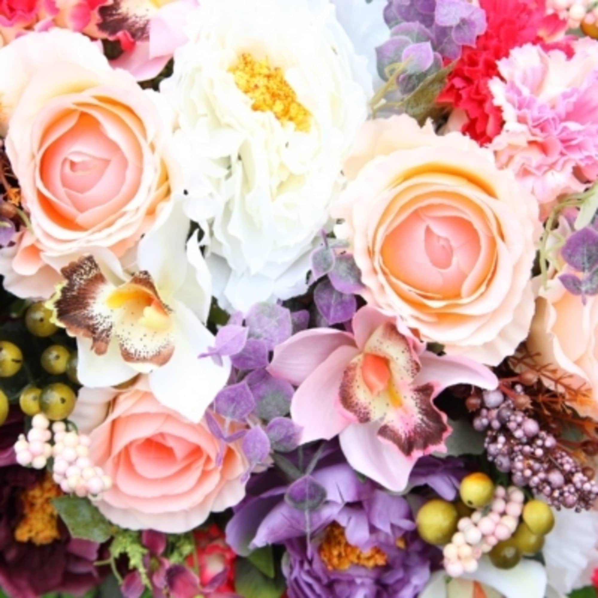 Bouquet of peach roses, white blooms, and pink flowers with purple accents