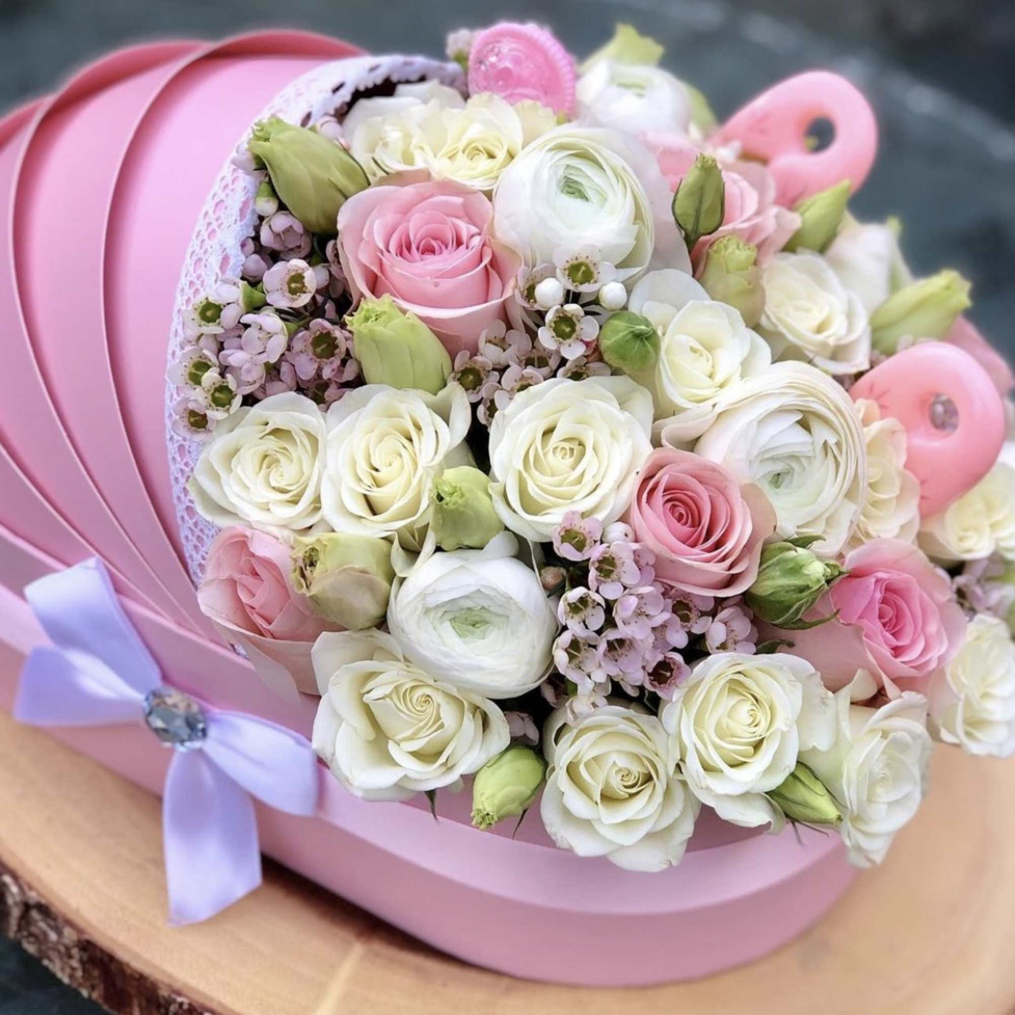 Pink and white rose bouquet in a pink hat box with a lavender ribbon