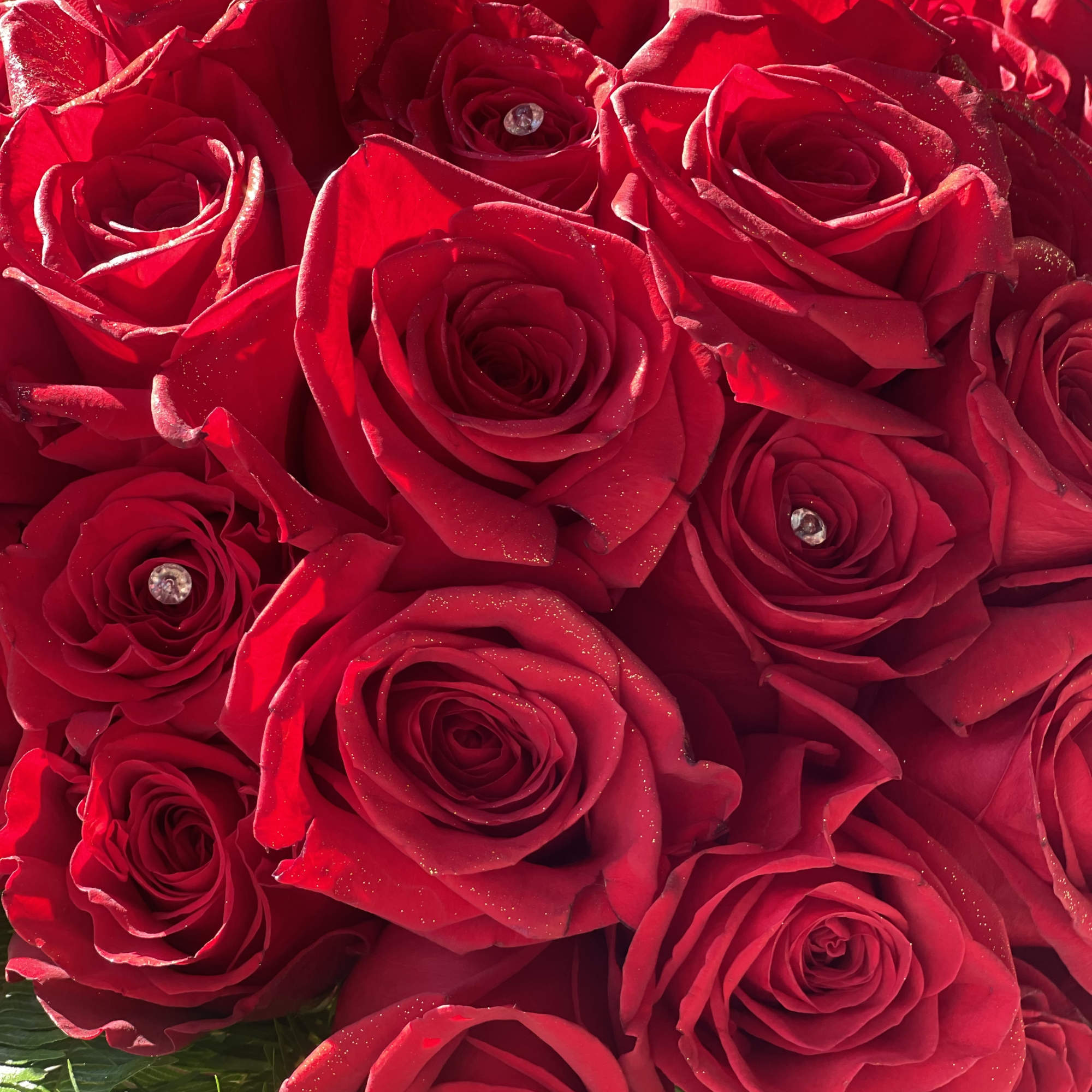 Close-up bouquet of red roses with small crystal accents