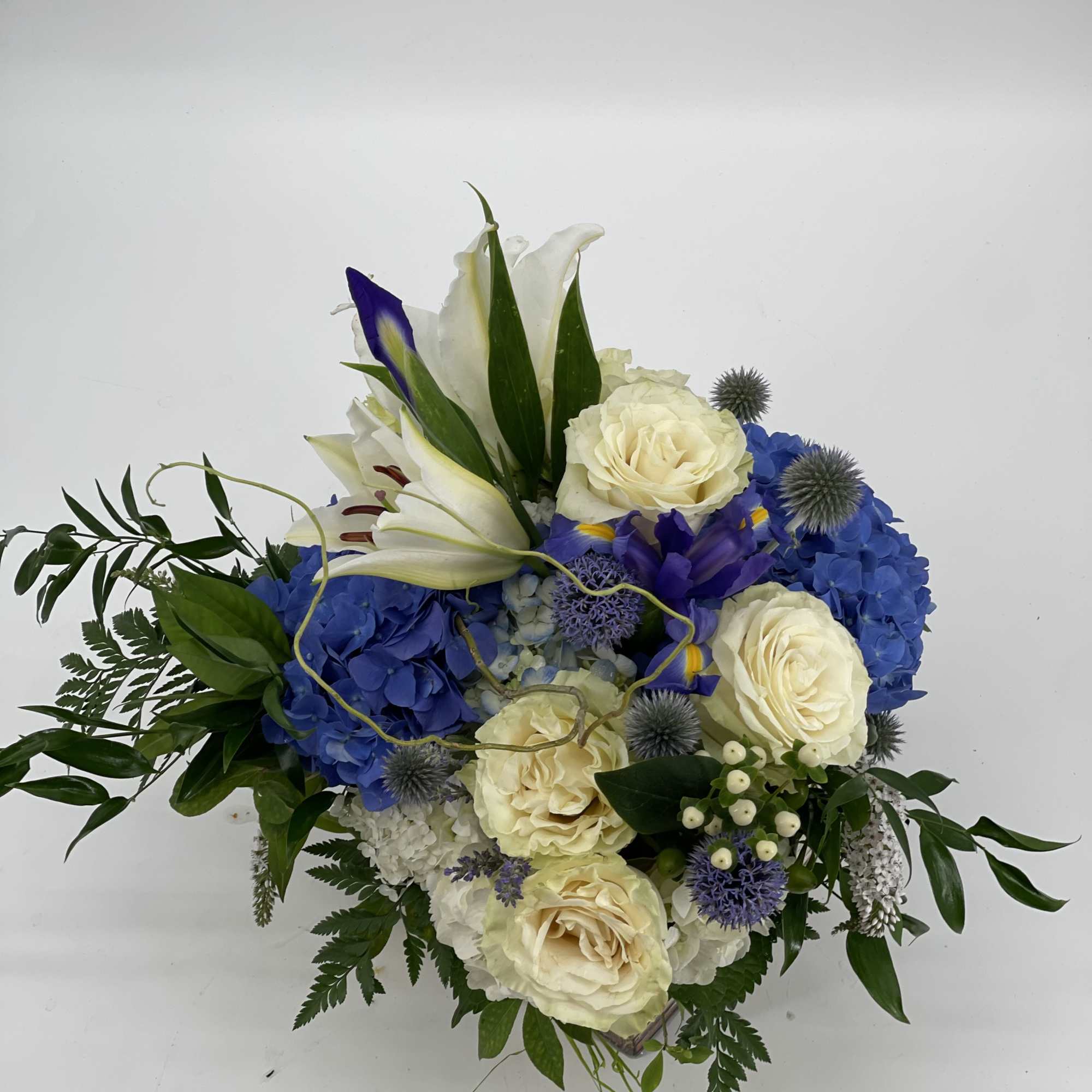 Blue and white floral arrangement with roses, lilies, and hydrangeas