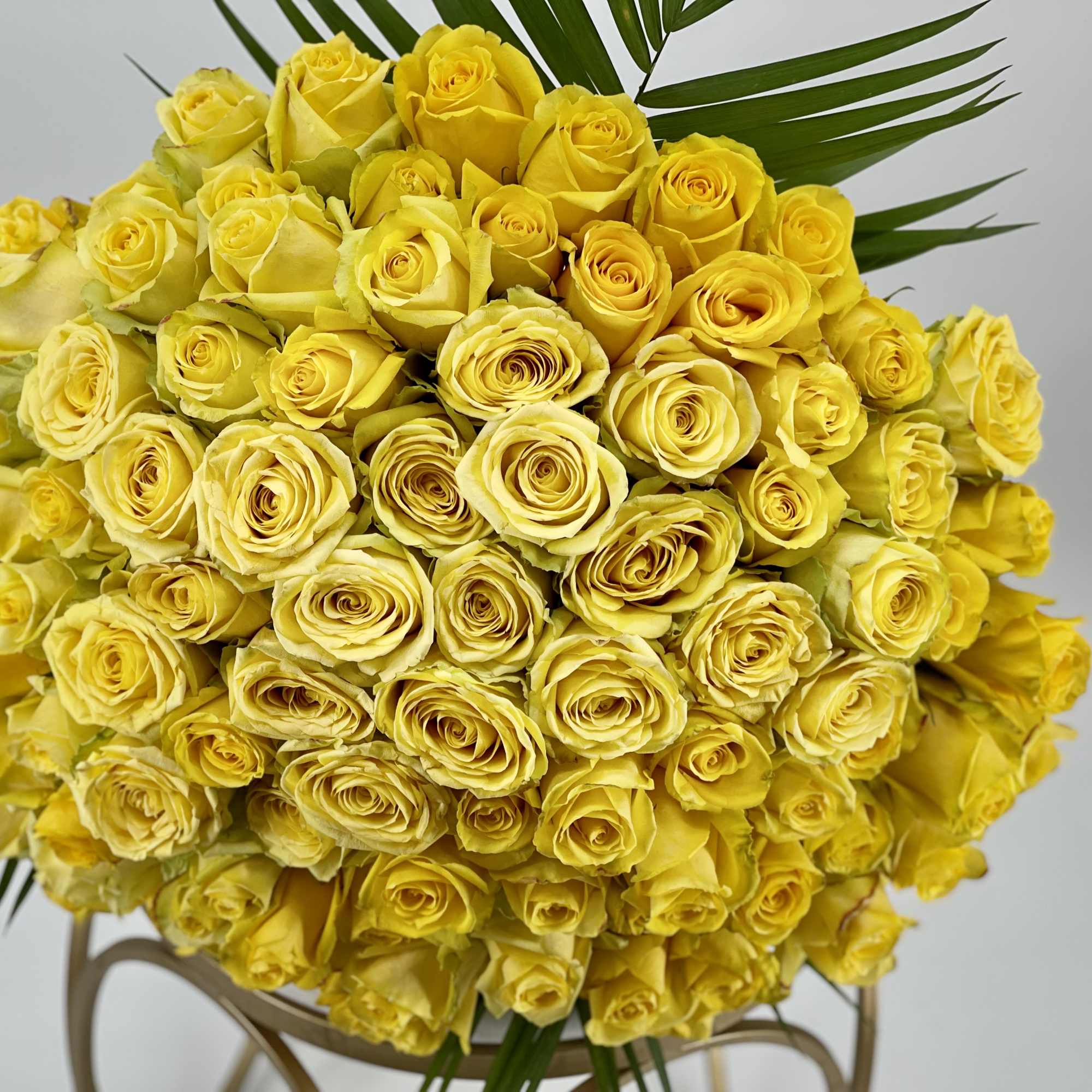 Large bouquet of yellow roses with palm leaves