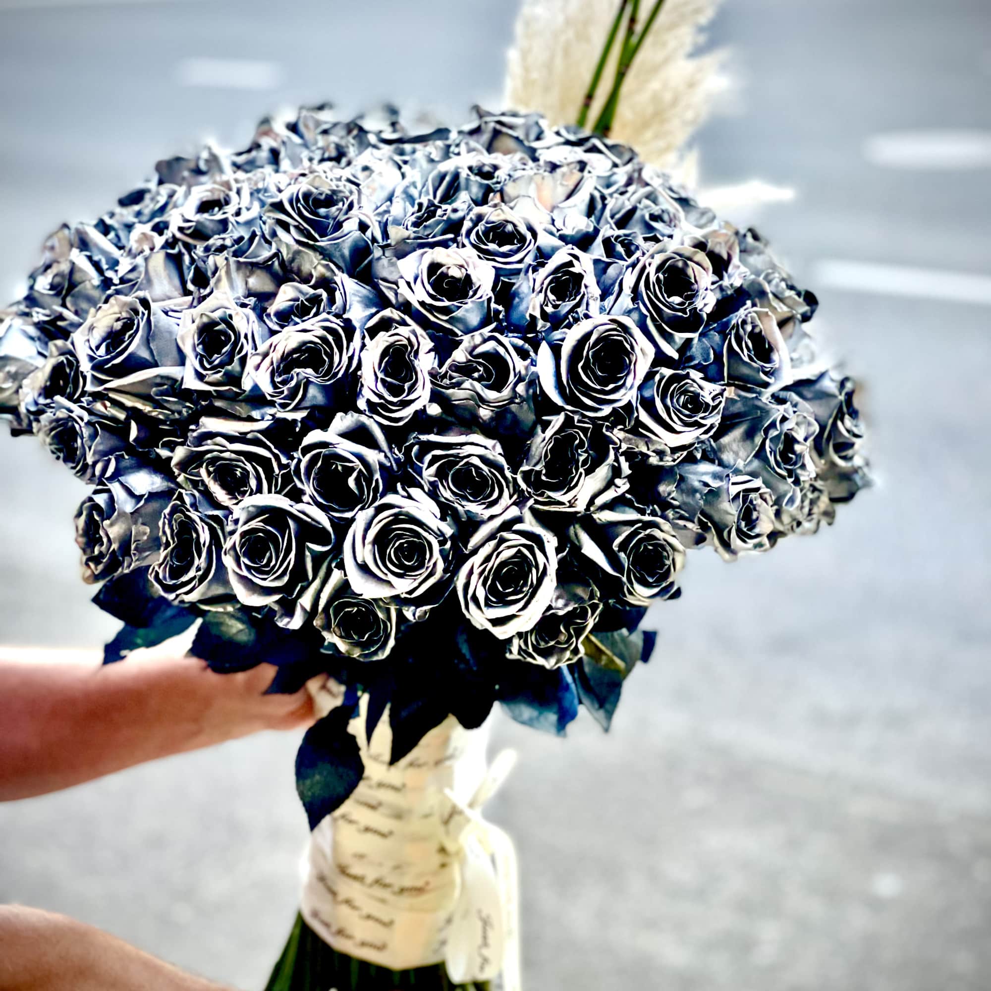 Large bouquet of dark roses wrapped with ribbon