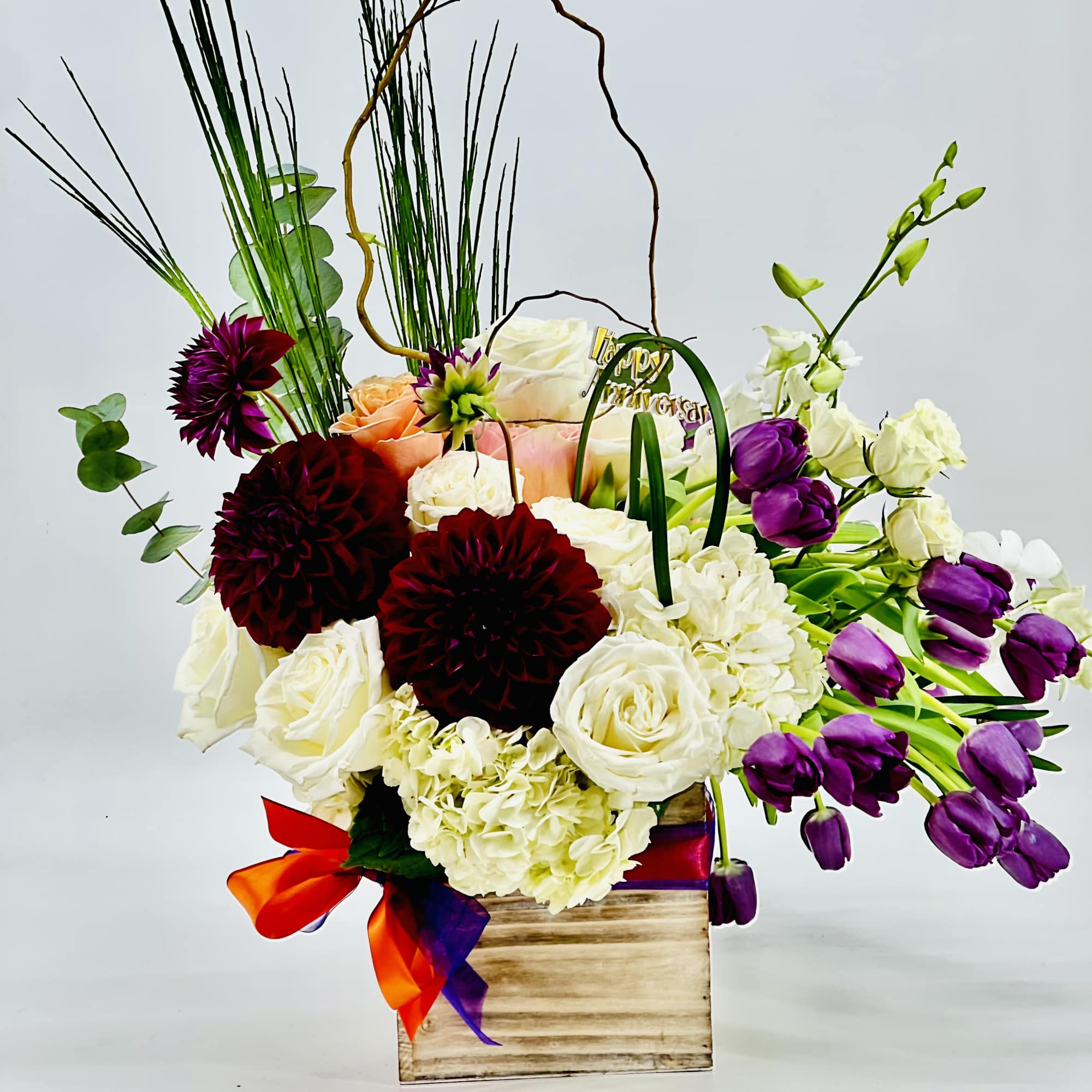 Mixed bouquet in a wooden box with white, purple, and burgundy flowers