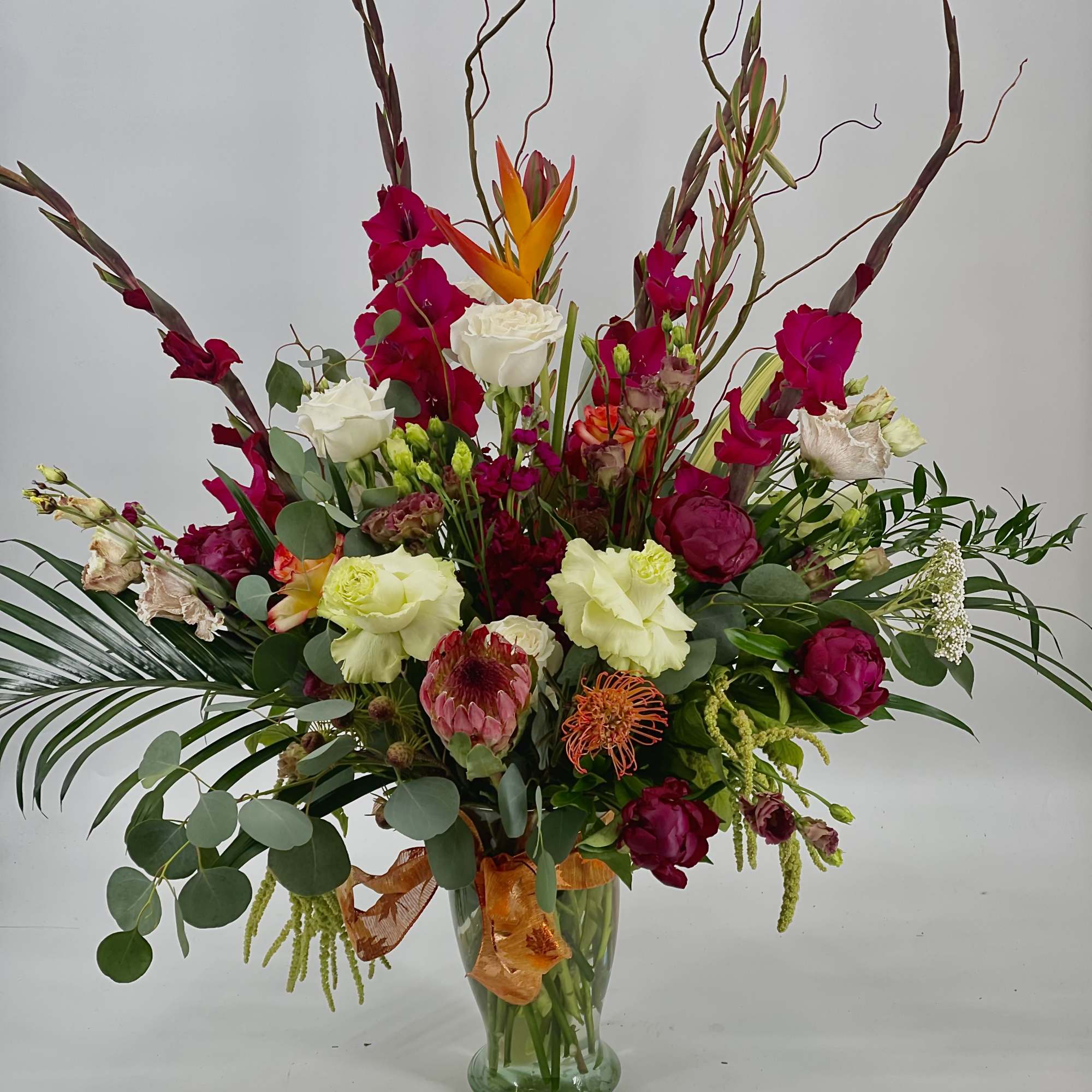 Tall mixed bouquet in a glass vase with pink, white, and orange blooms