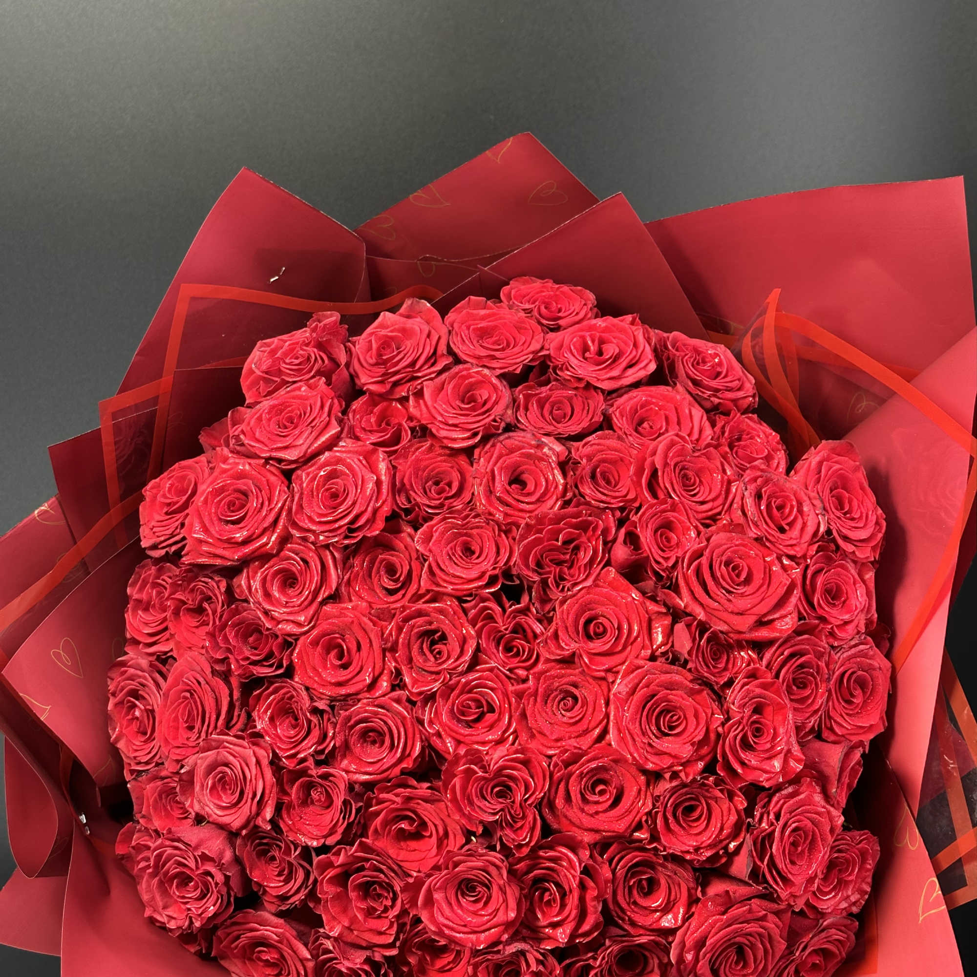Large bouquet of red roses wrapped in red paper