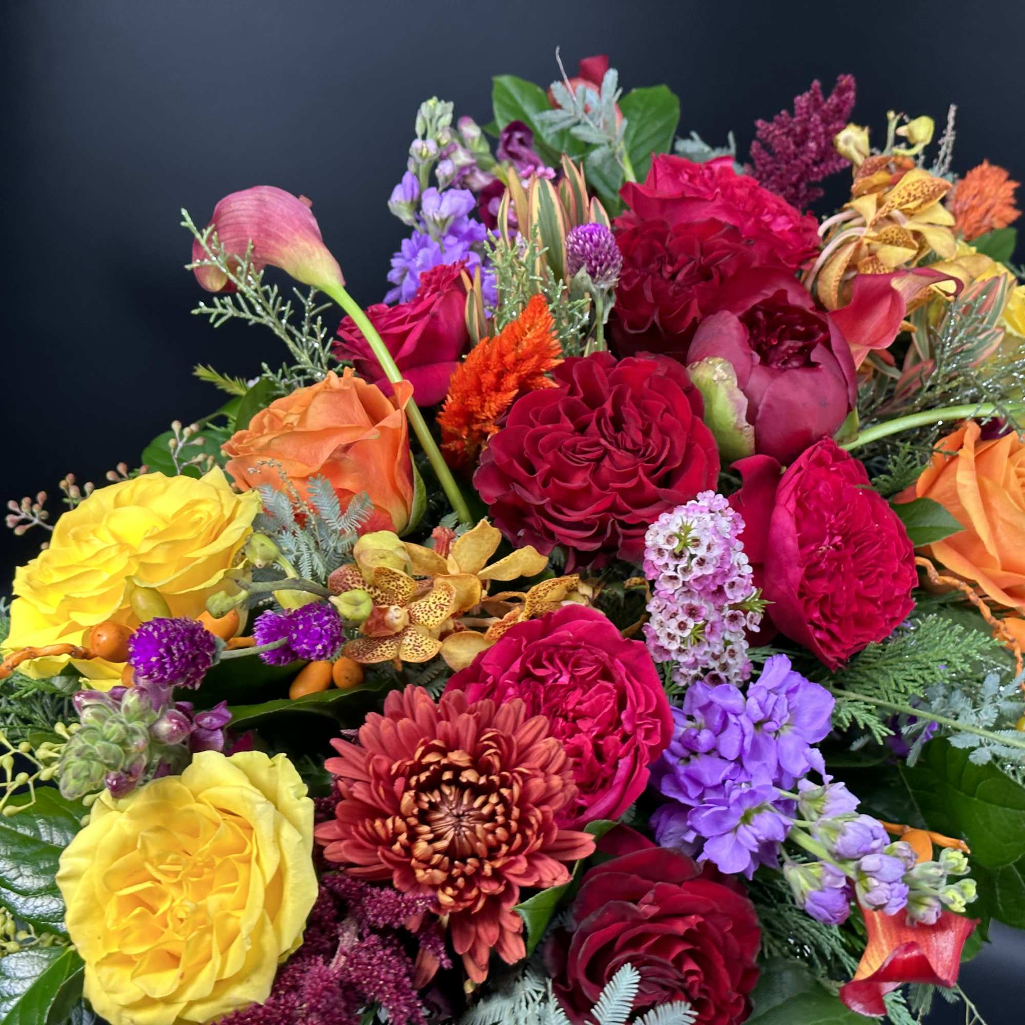 Bright mixed bouquet with roses, calla lilies, and purple blooms