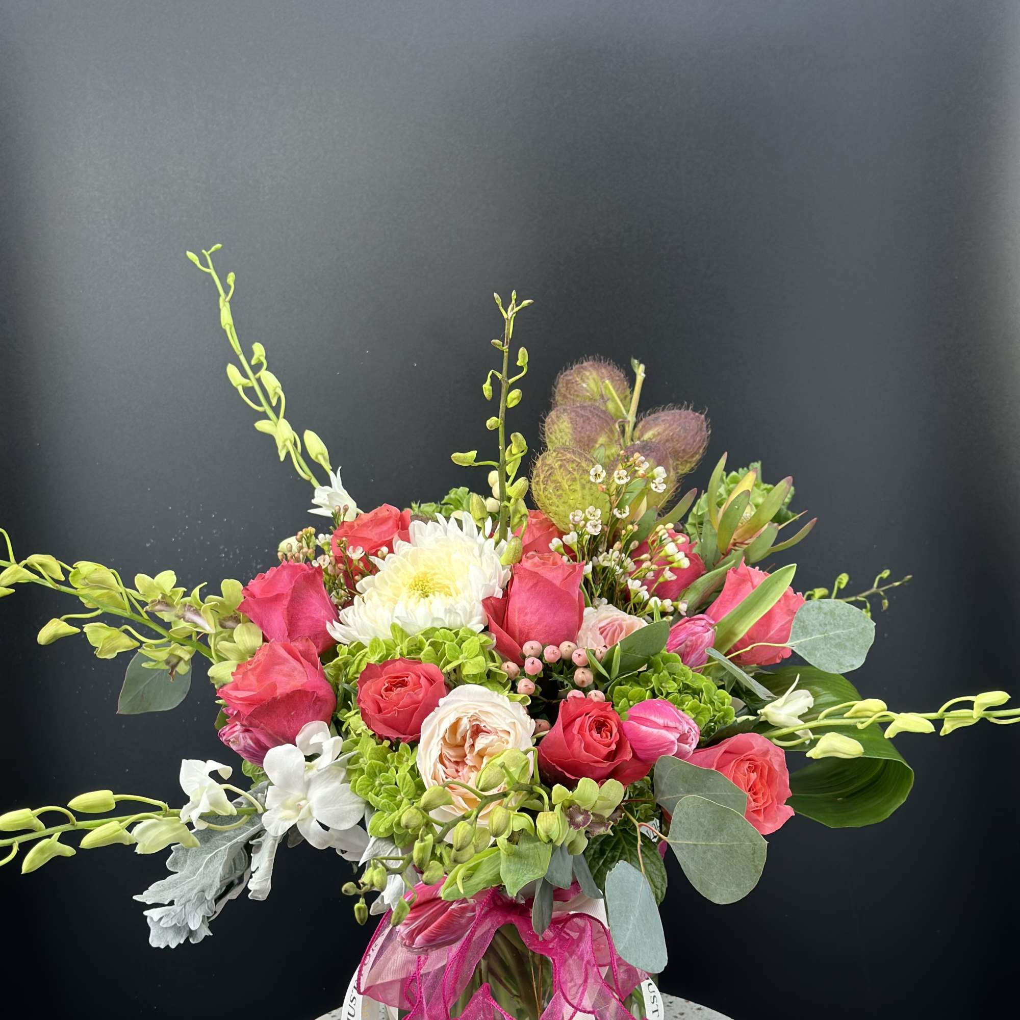 Pink and white mixed bouquet in a glass vase with a ribbon bow