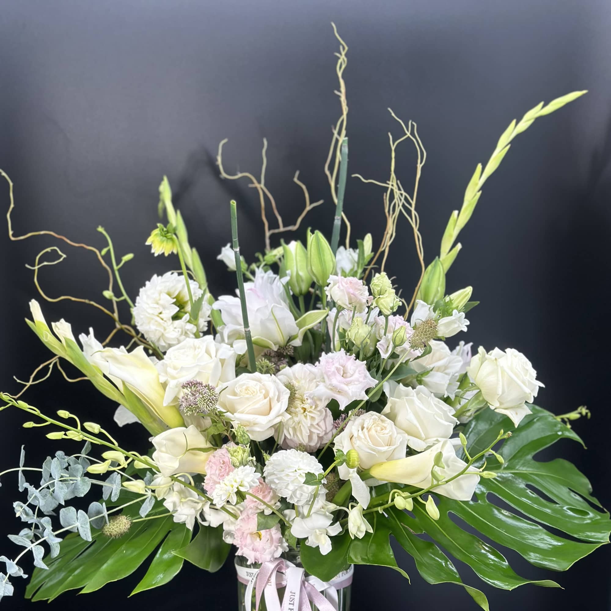 White floral arrangement in a glass vase with pink accents