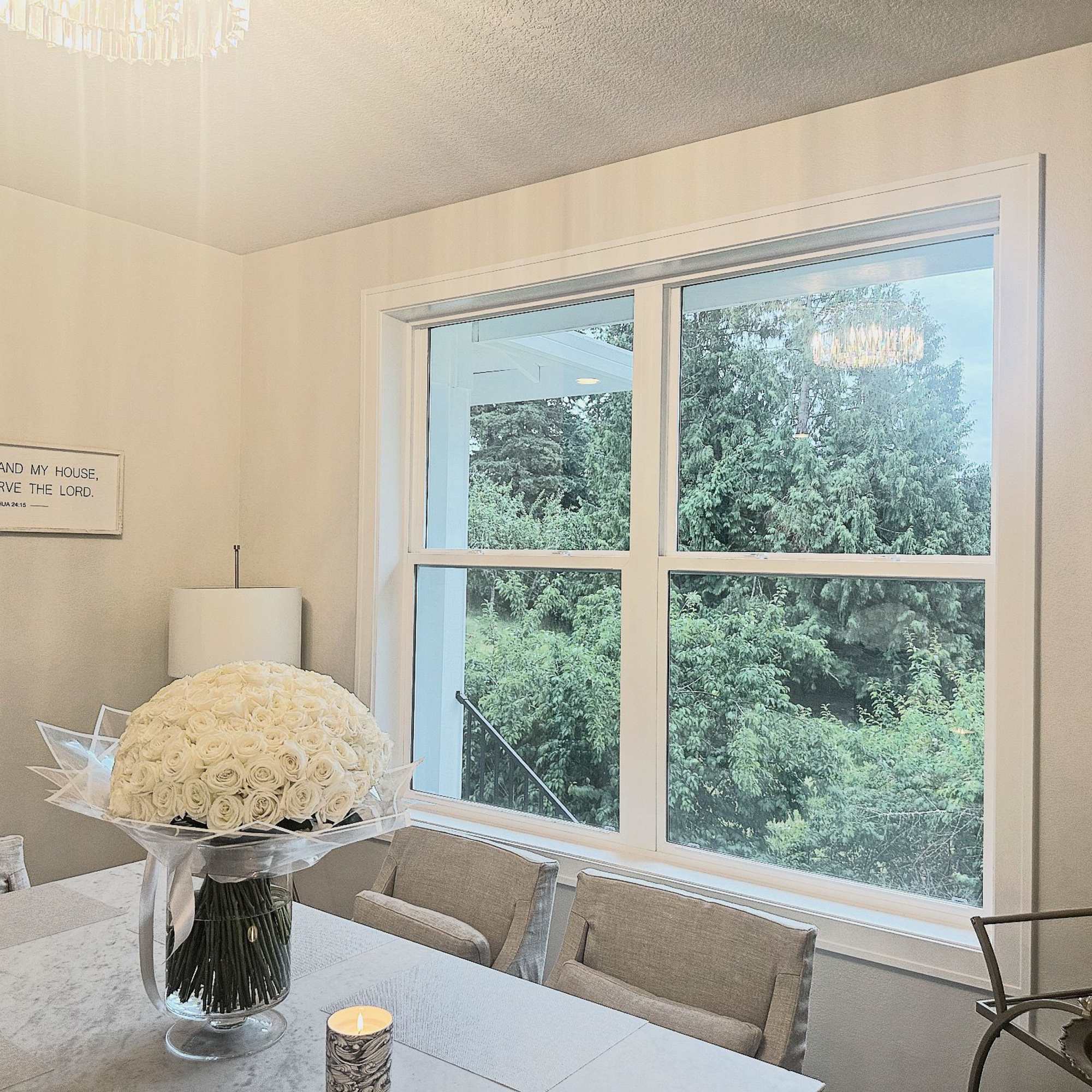 White rose bouquet in a clear glass vase on a dining table