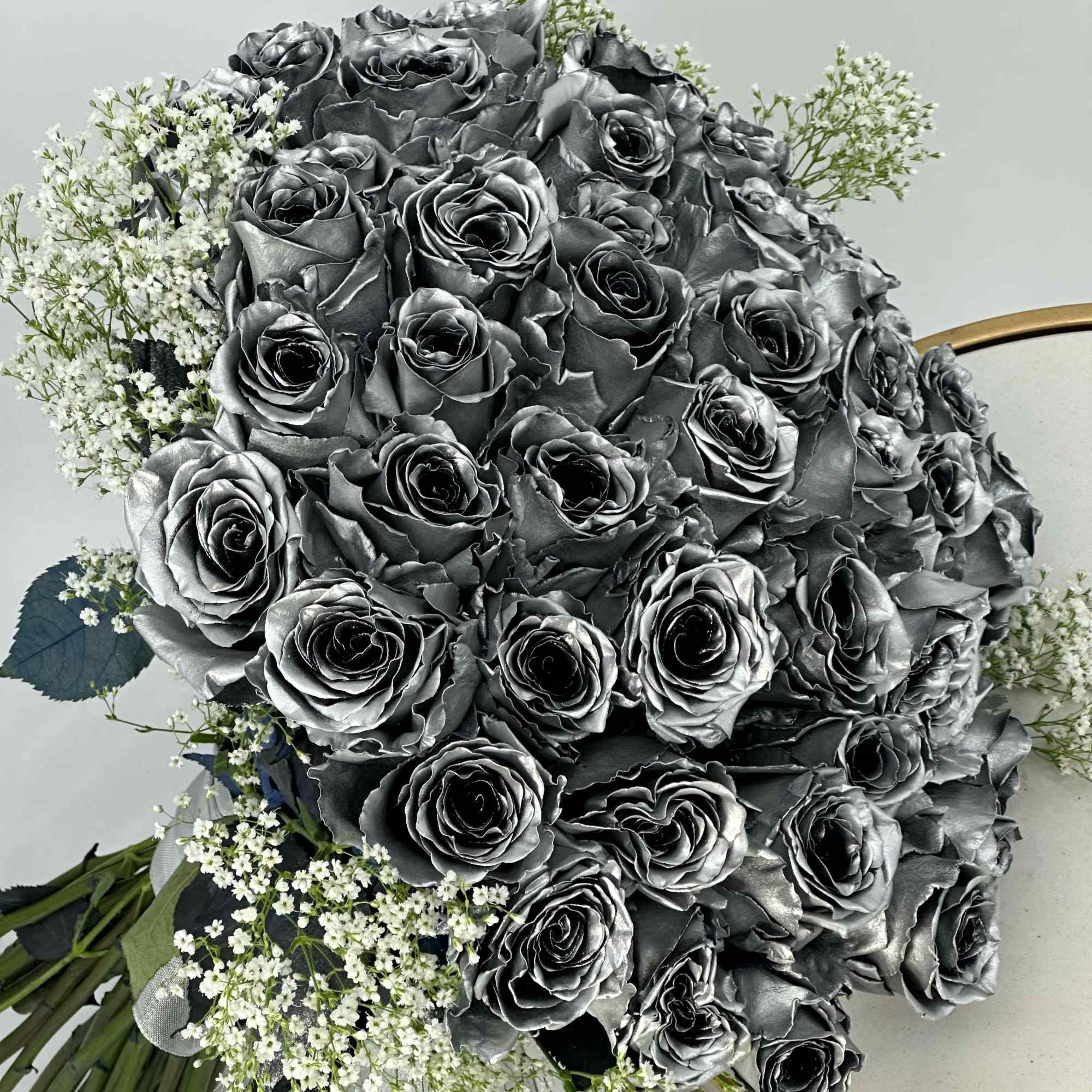 Large bouquet of metallic gray roses with small white filler flowers