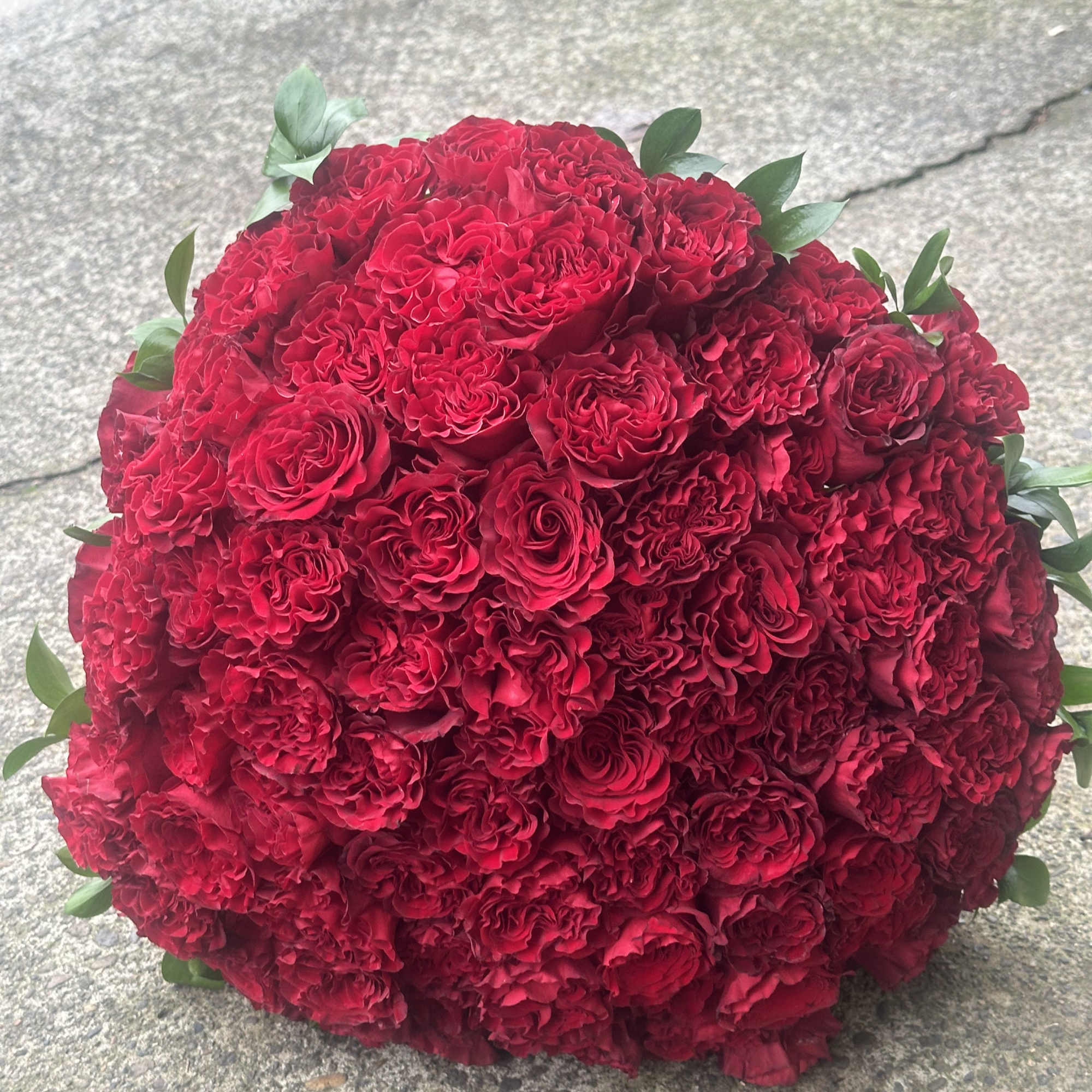 Large dome bouquet of red roses with a few green leaves, photo 3 of 7
