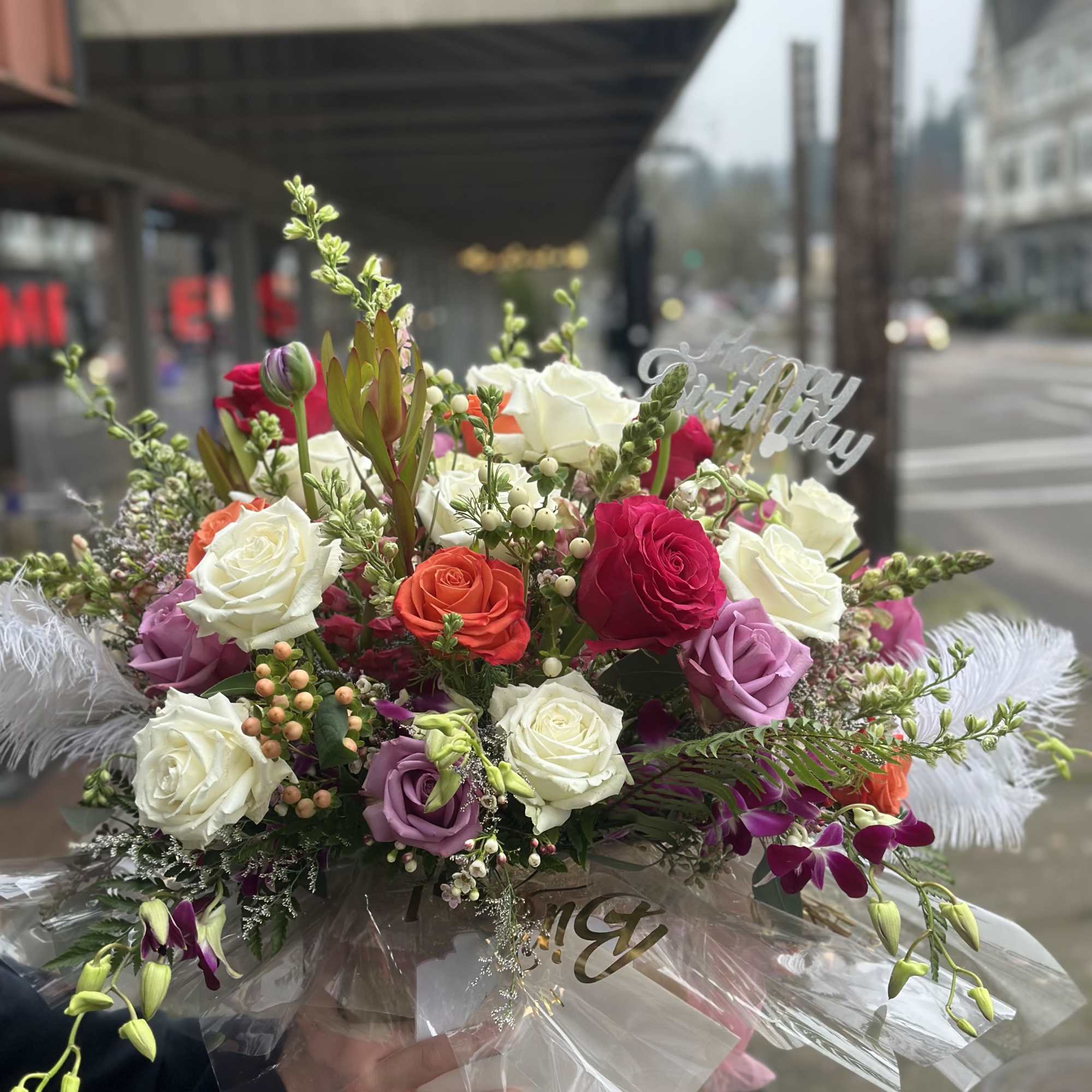 Mixed rose bouquet with a birthday topper and white feathers