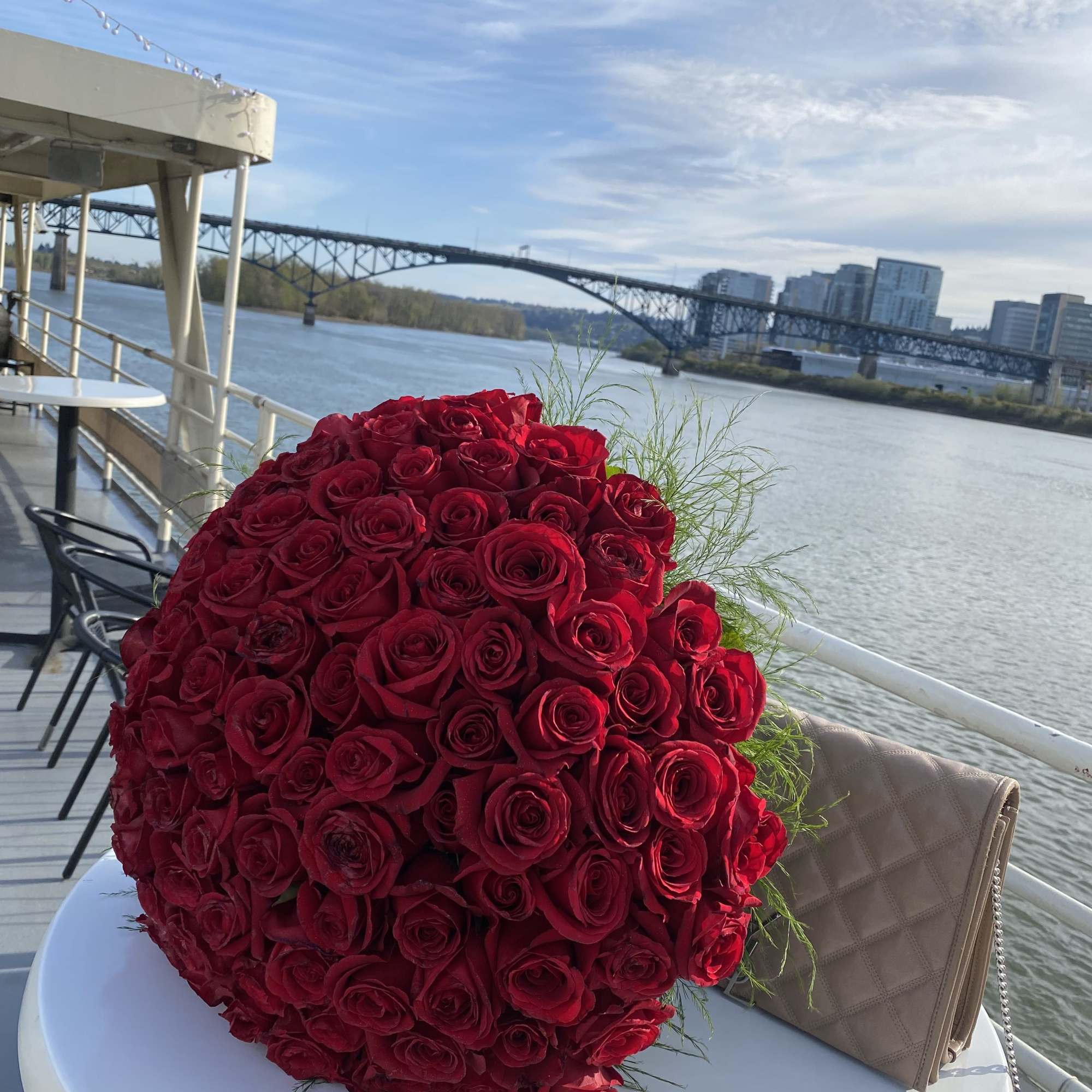 Large bouquet of red roses on a table by the water