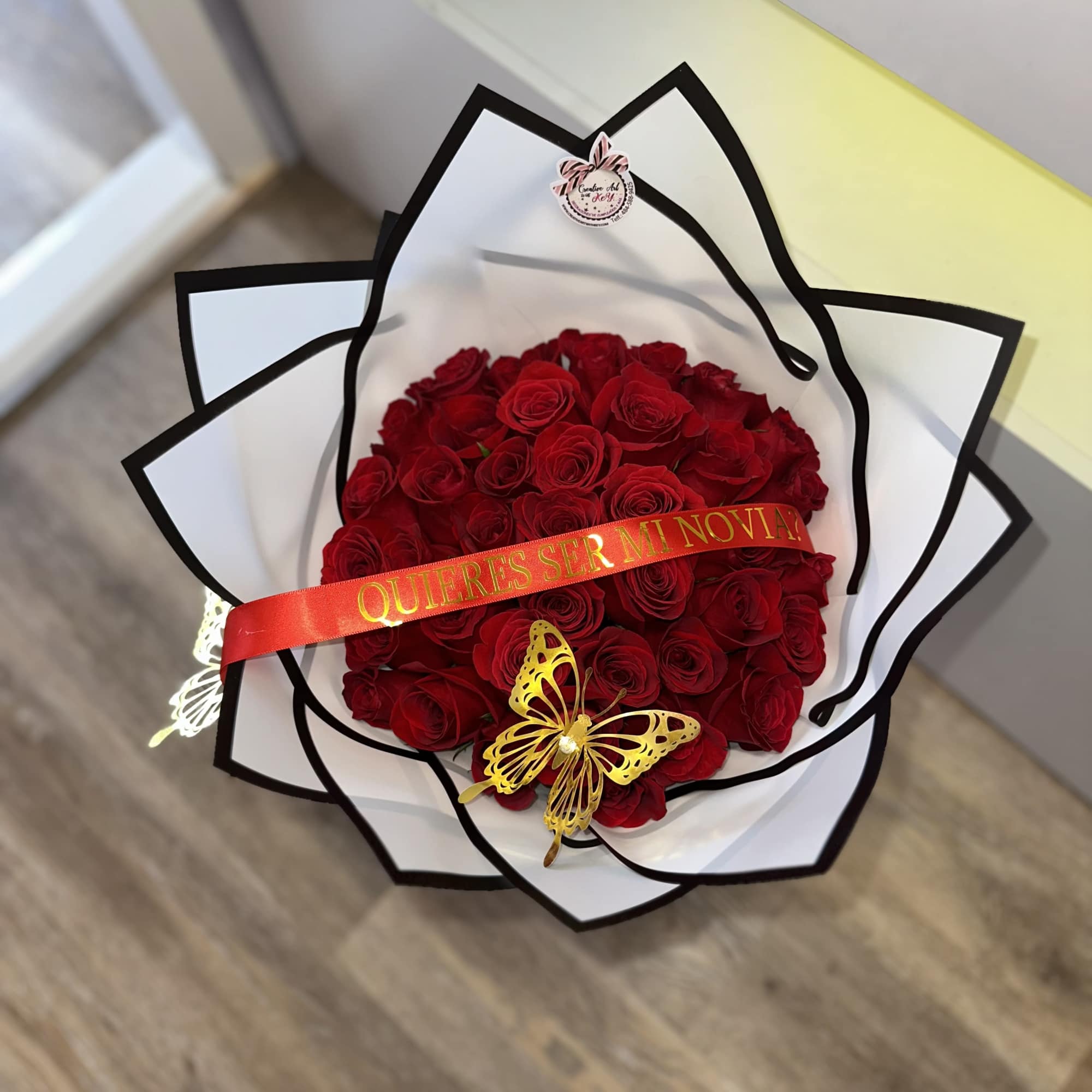 Bouquet of red roses wrapped in white paper with a red ribbon