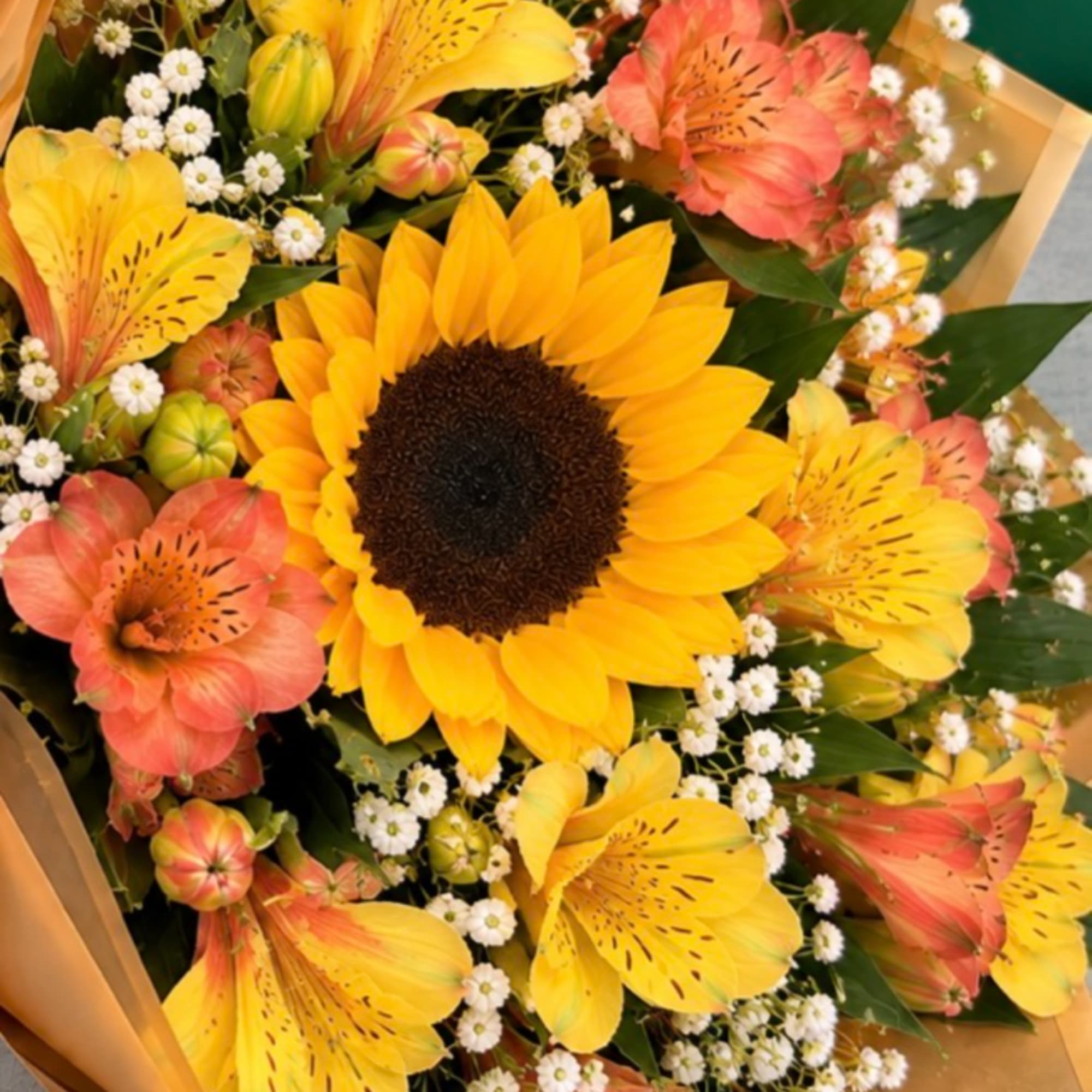 Bouquet with a large yellow sunflower and coral alstroemeria flowers