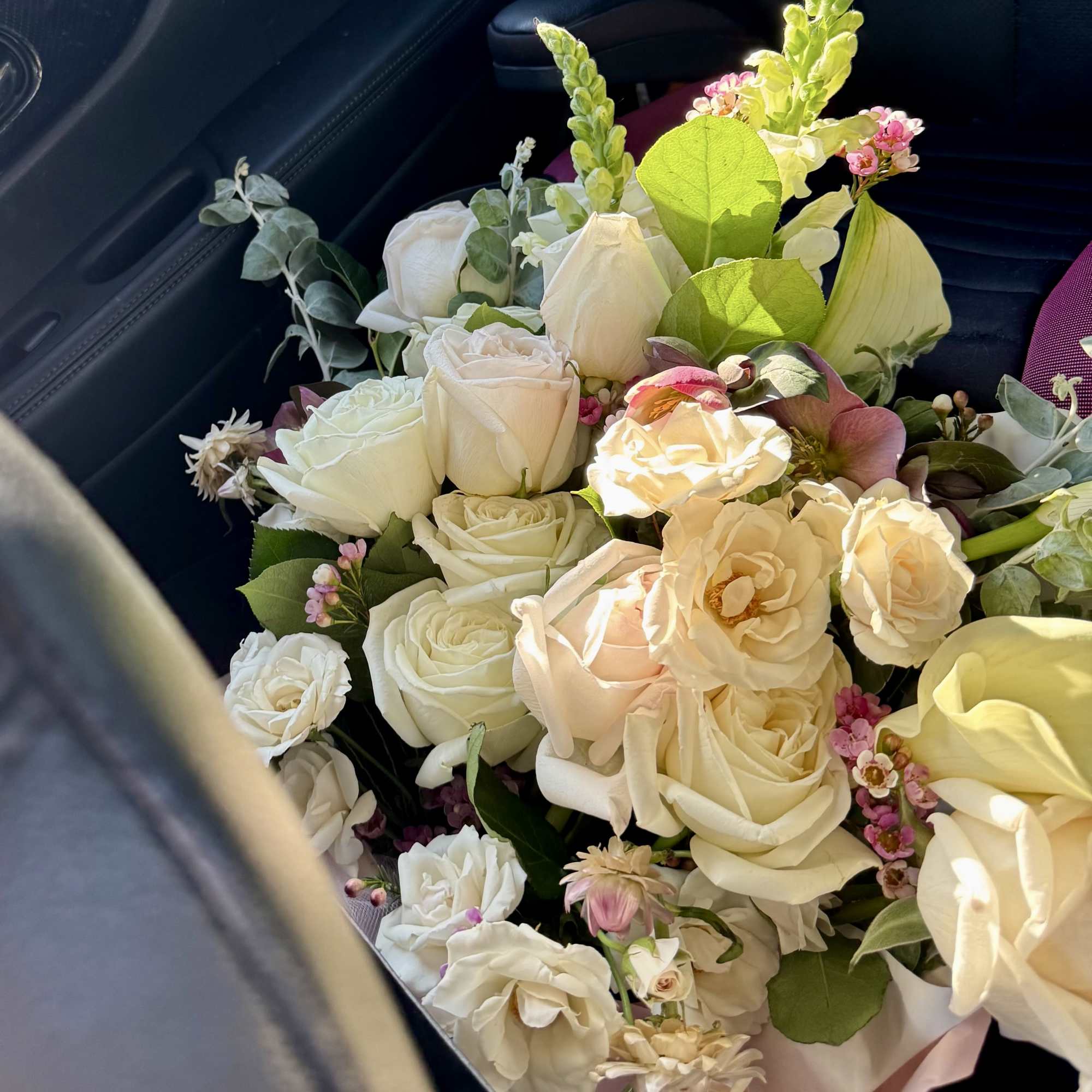 Bouquet of cream and blush roses with small pink accents