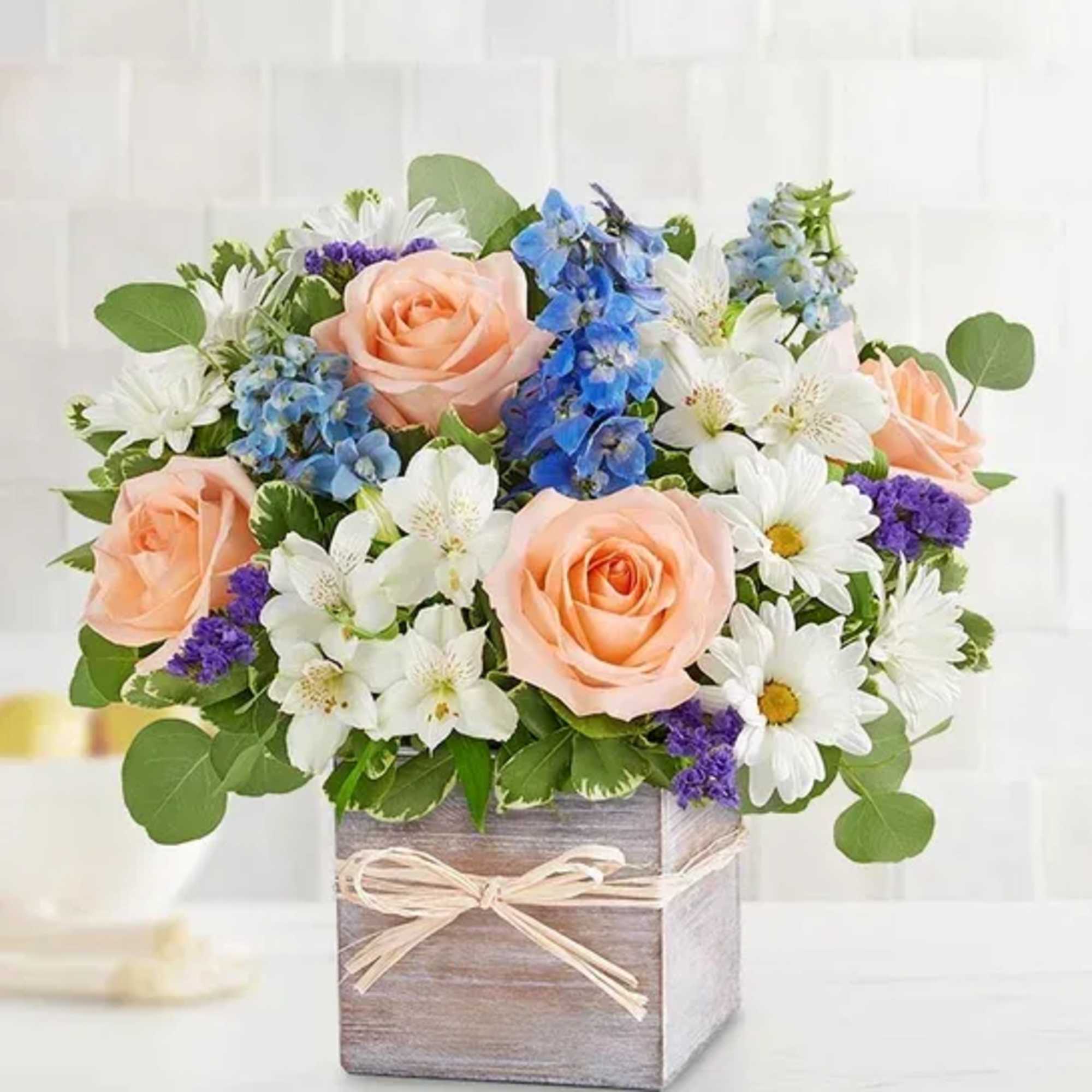 Peach roses and white daisies in a wooden box arrangement