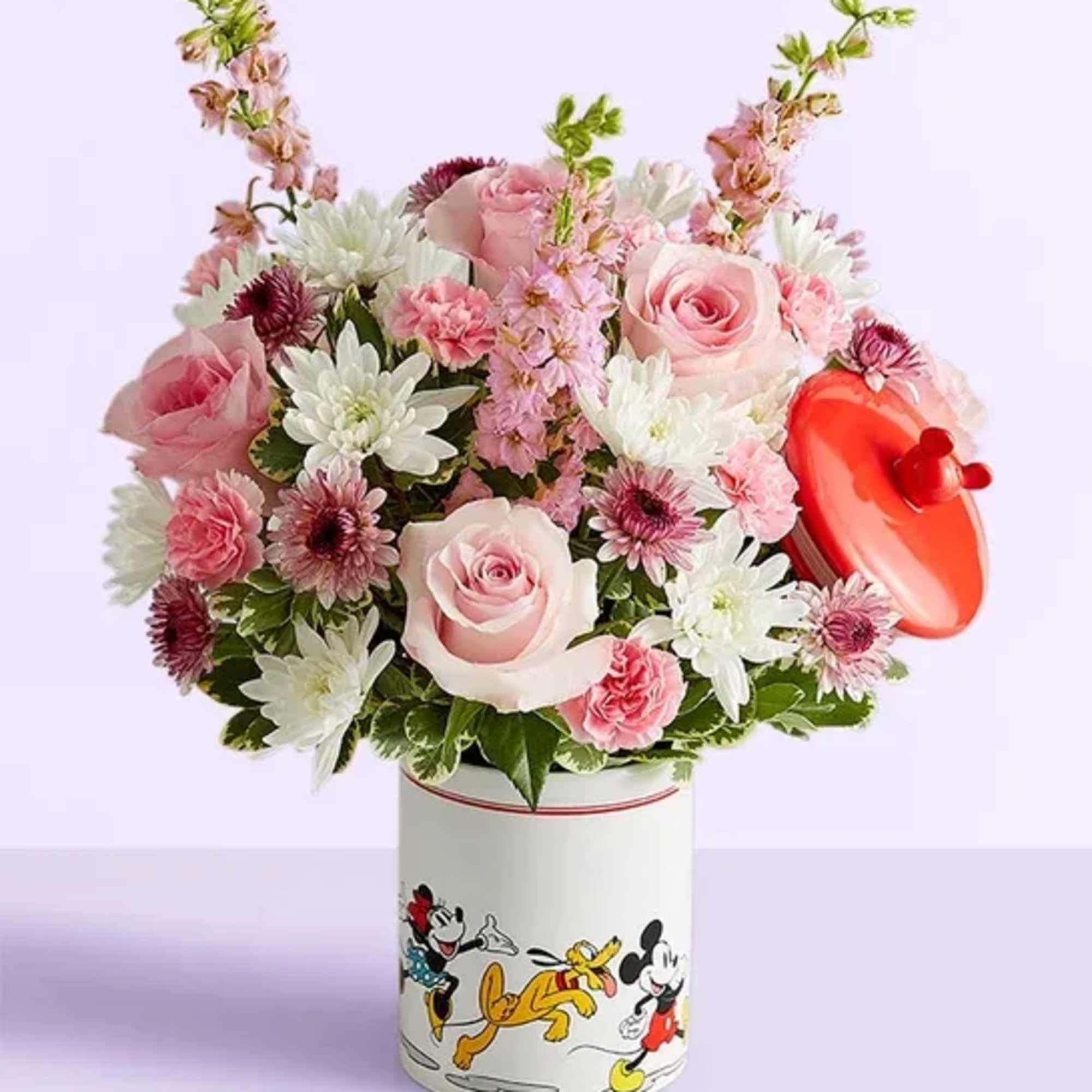 Pink and white flower arrangement in a Mickey Mouse tin with a red heart topper