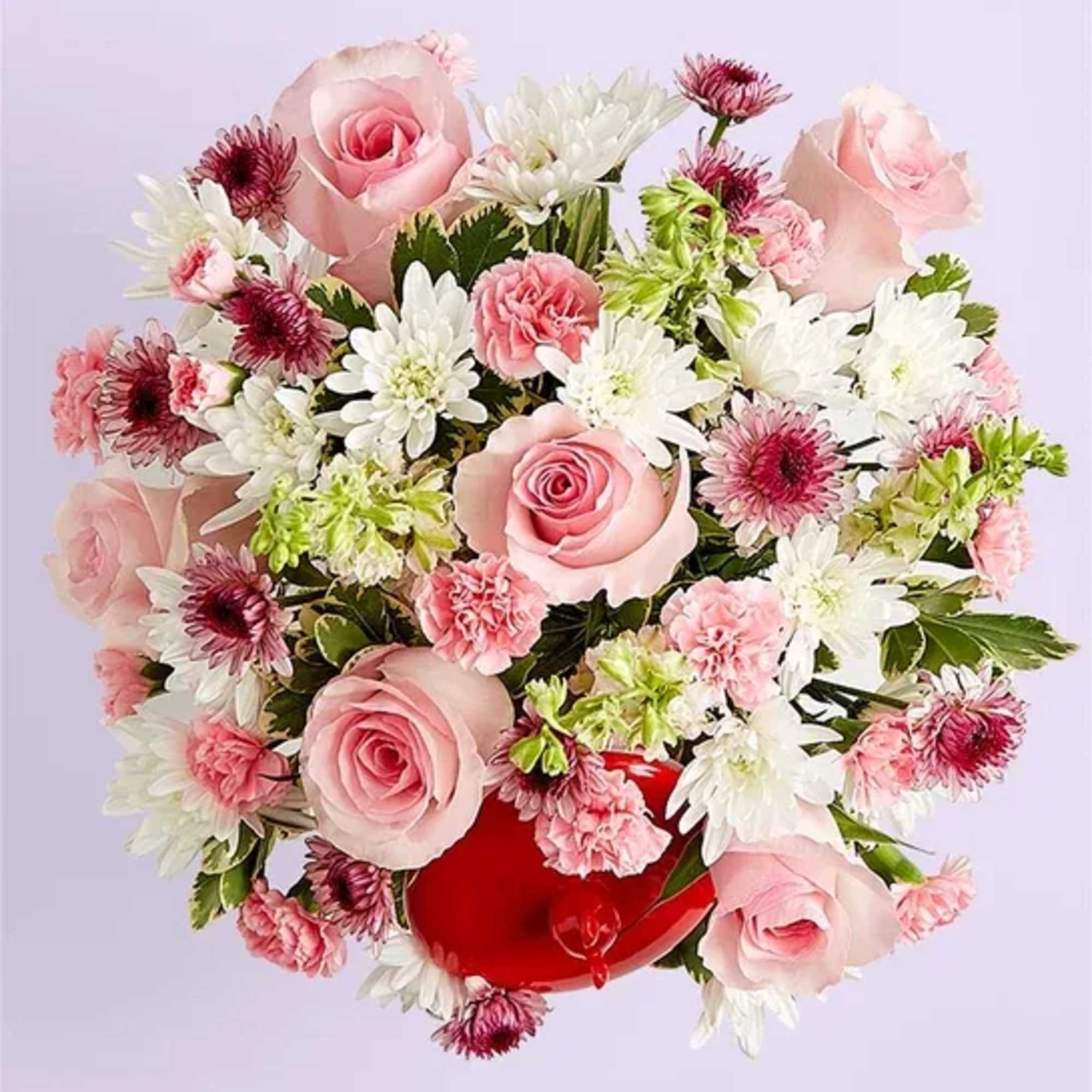 Bouquet of pink roses, white daisies, and carnations in a red heart-shaped box