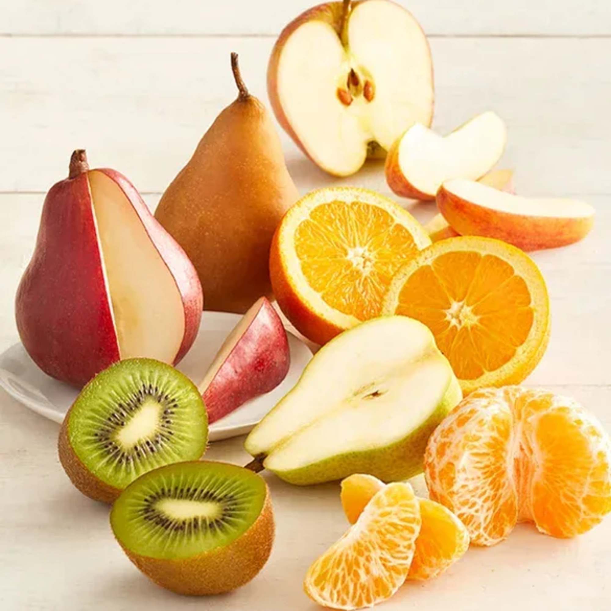 Assorted sliced fruit including pears, oranges, kiwi, and tangerines