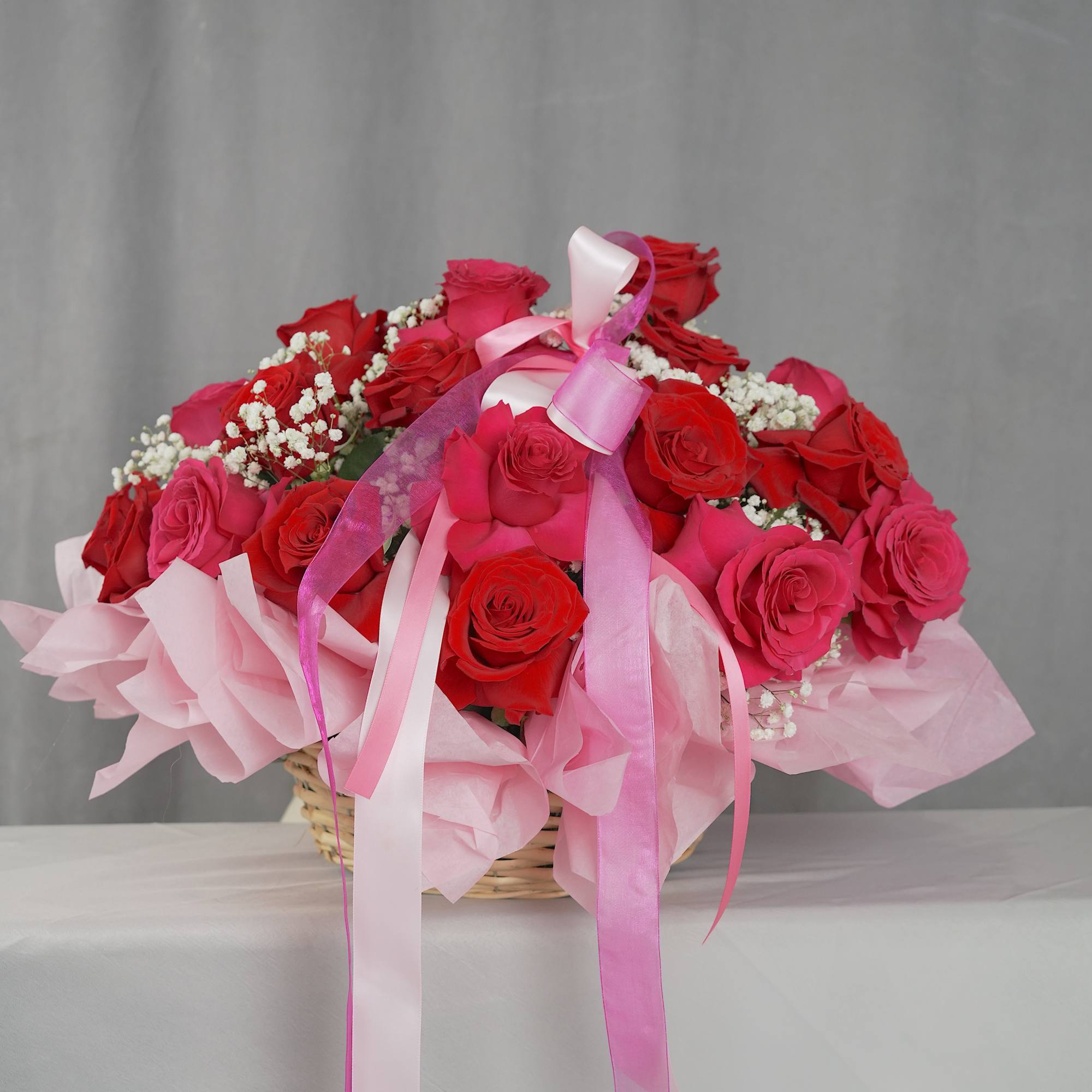 Basket of red and pink roses with pink ribbons, photo 3 of 4