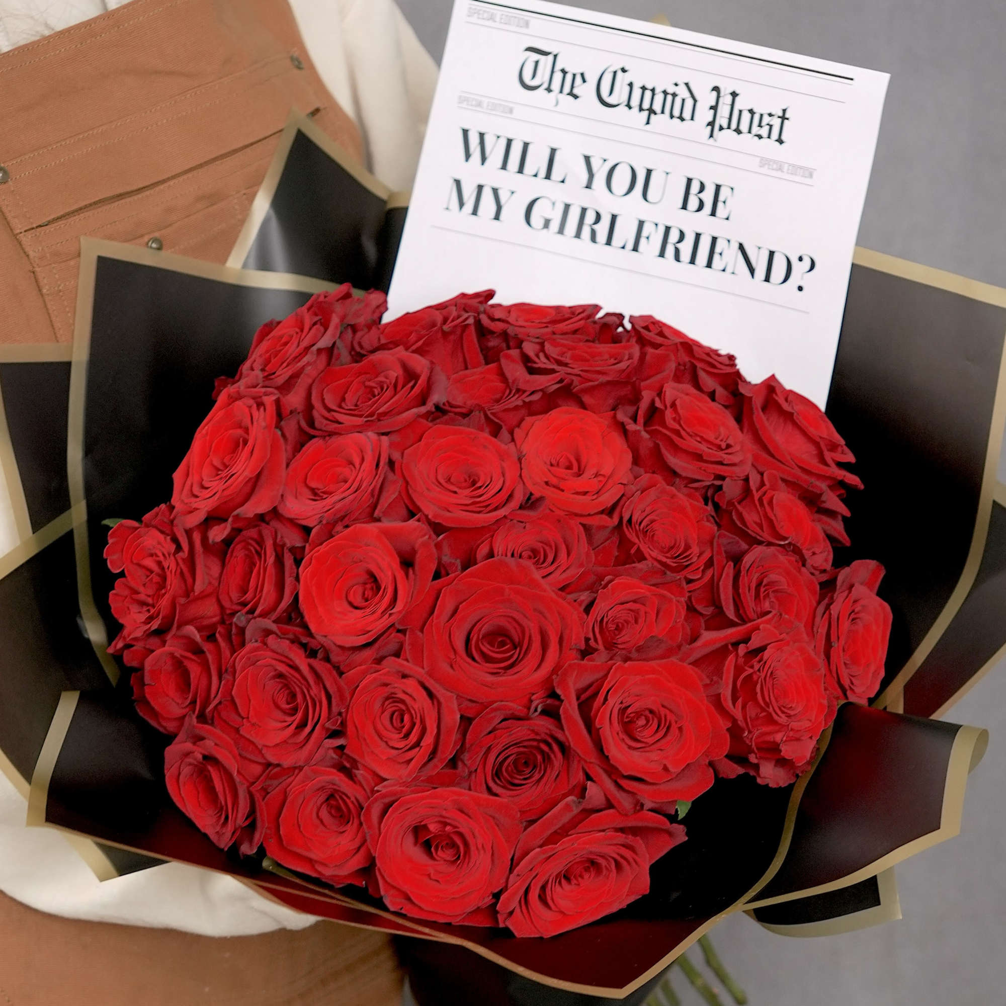Bouquet of red roses with a proposal card