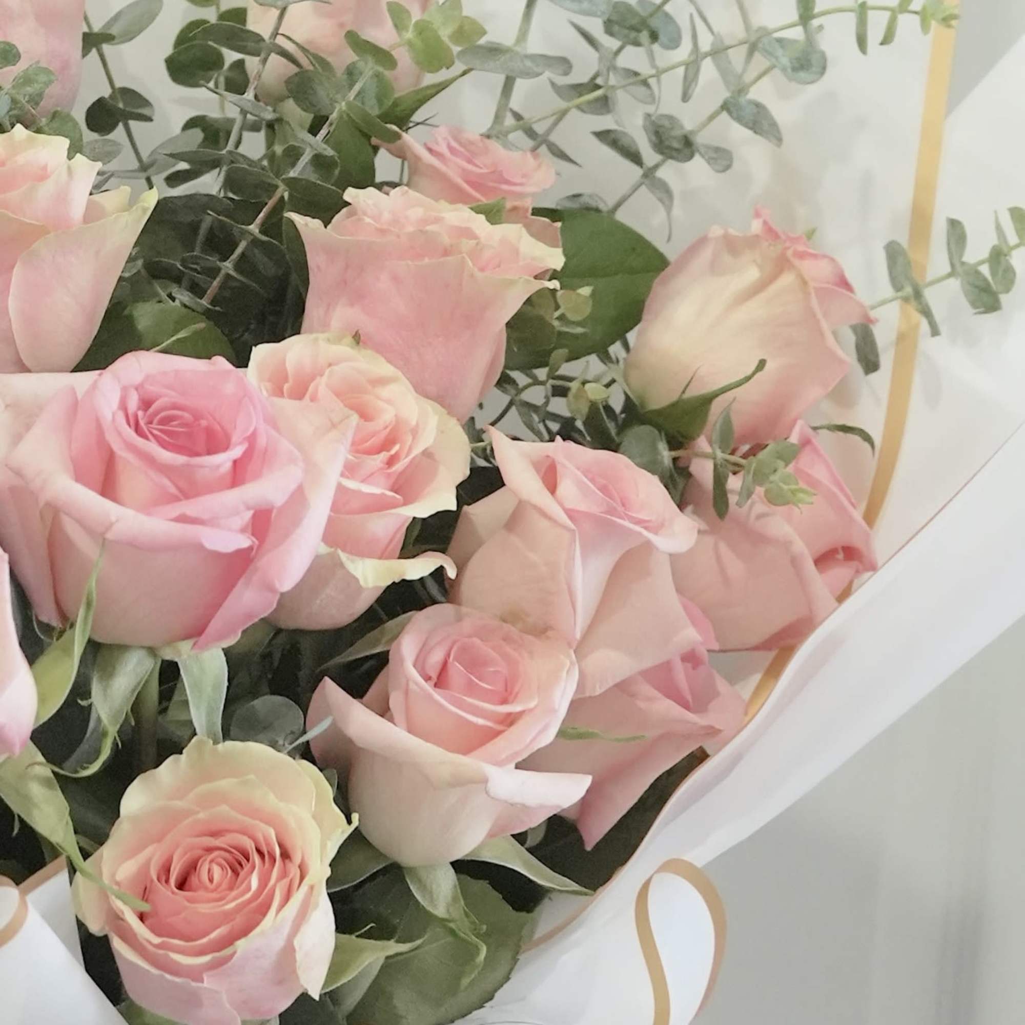 A dense cluster of  pink roses forms a rounded hand-tied bouquet, photo 2 of 2