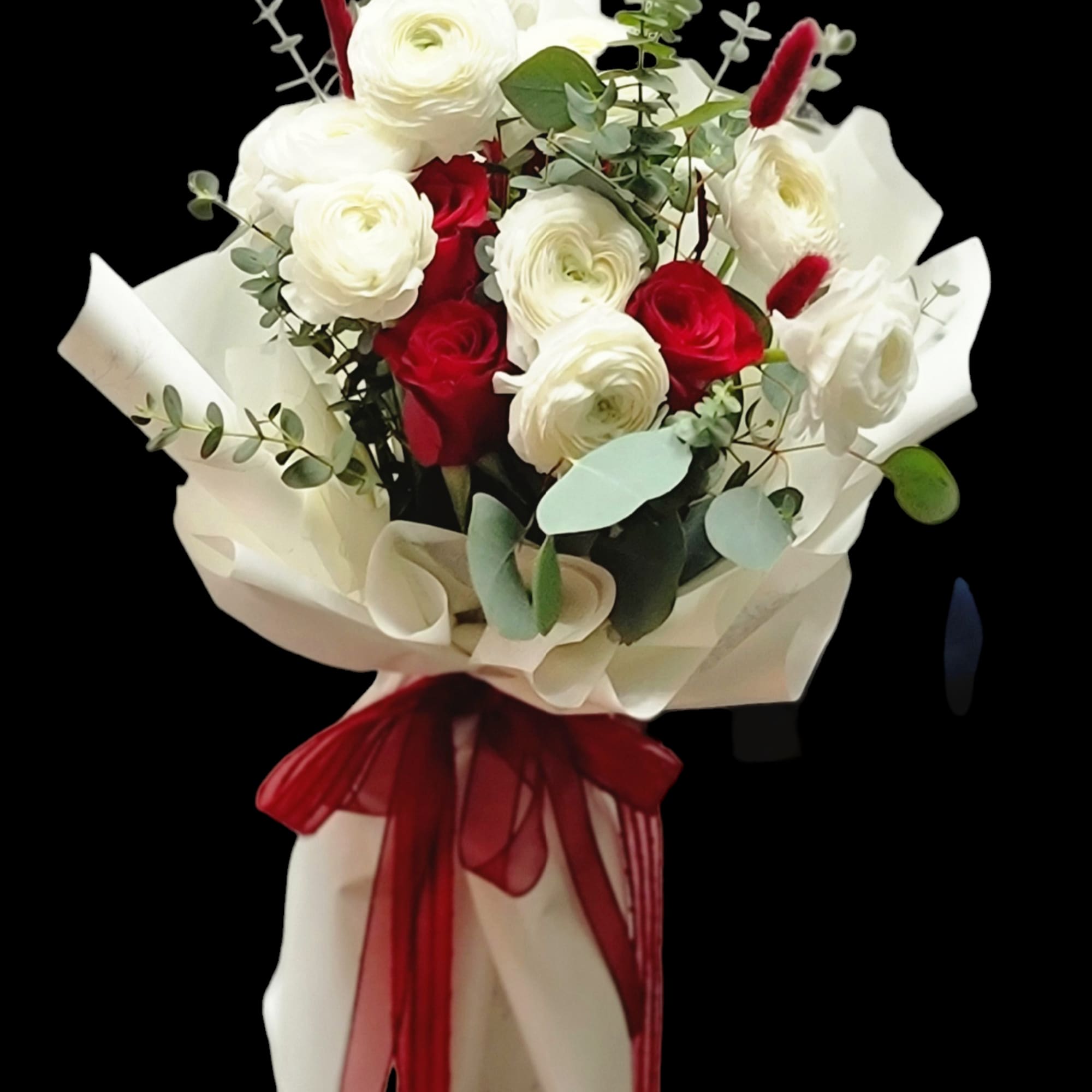Bouquet of red and white roses wrapped in cream paper with a red ribbon