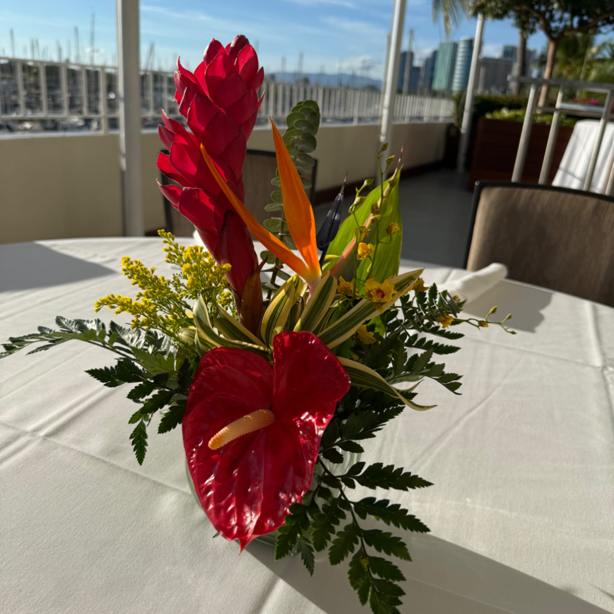Tropical flower arrangement with red anthurium and bird of paradise on a table