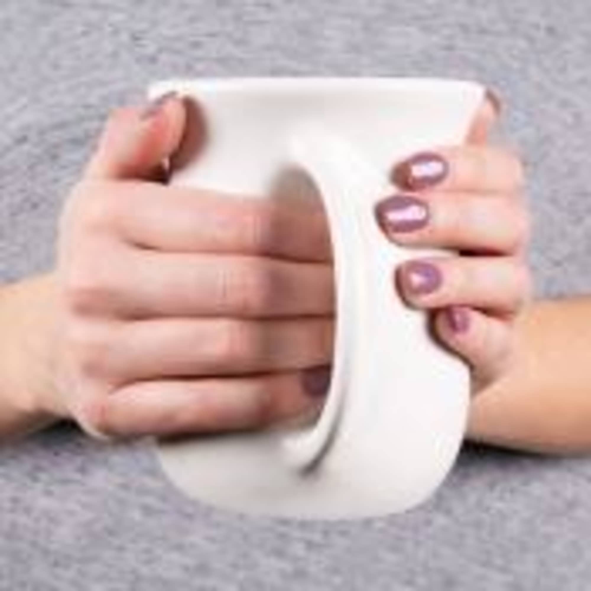Hands holding a white ceramic mug