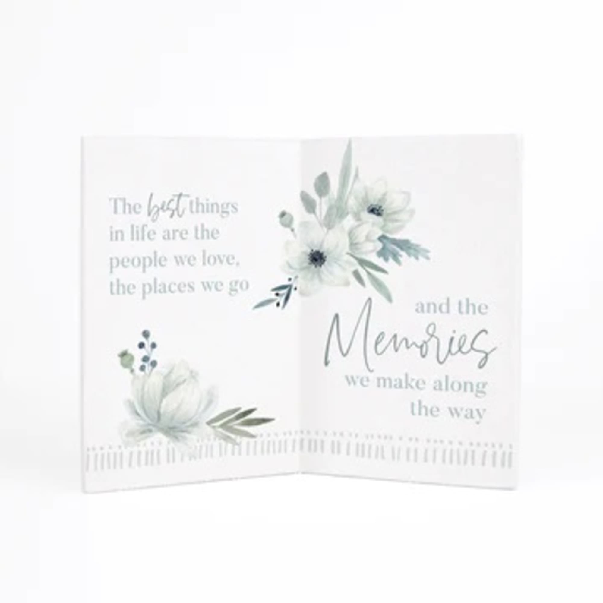 Folded sympathy card with white flowers and memorial text