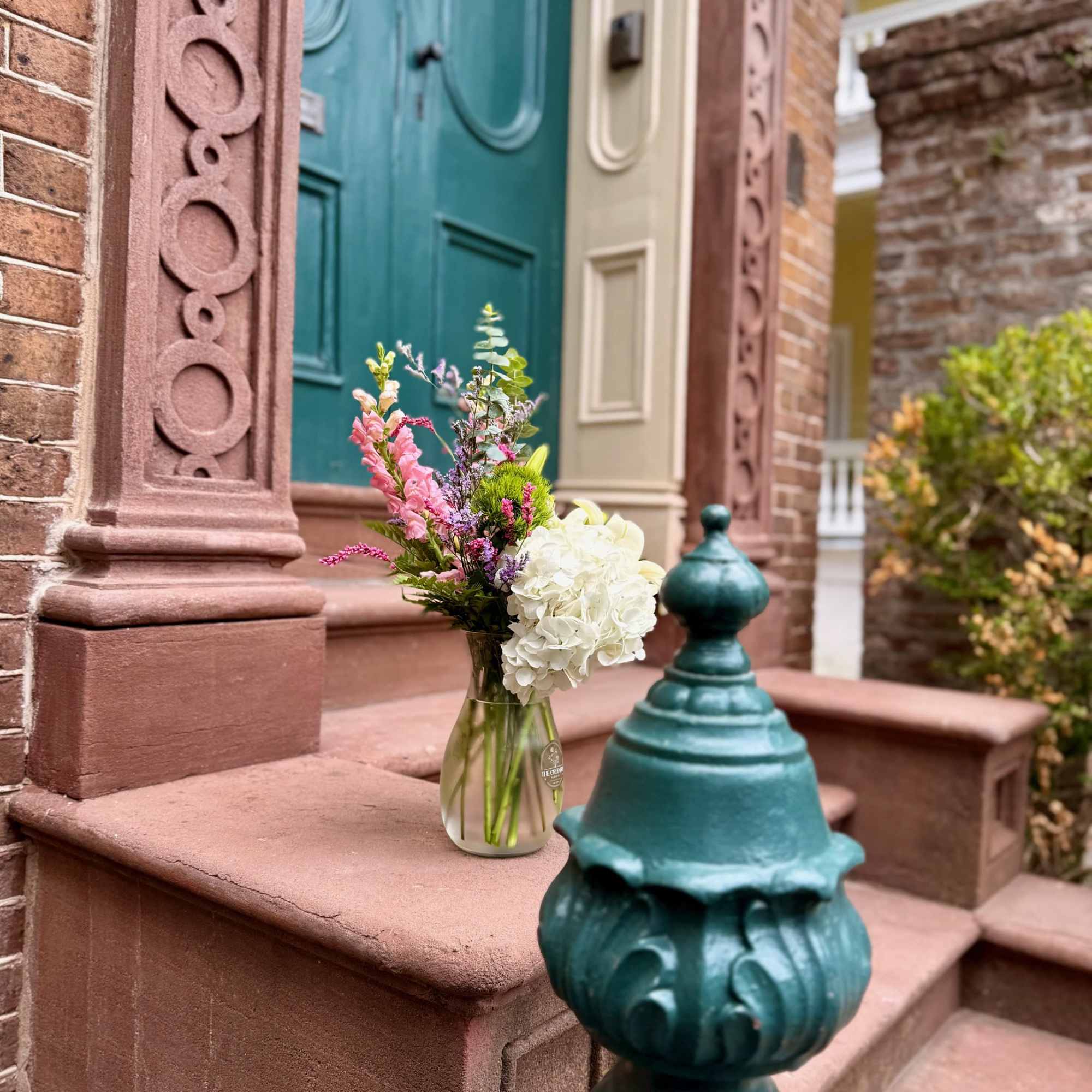 Mixed bouquet in a glass vase on a brownstone stoop